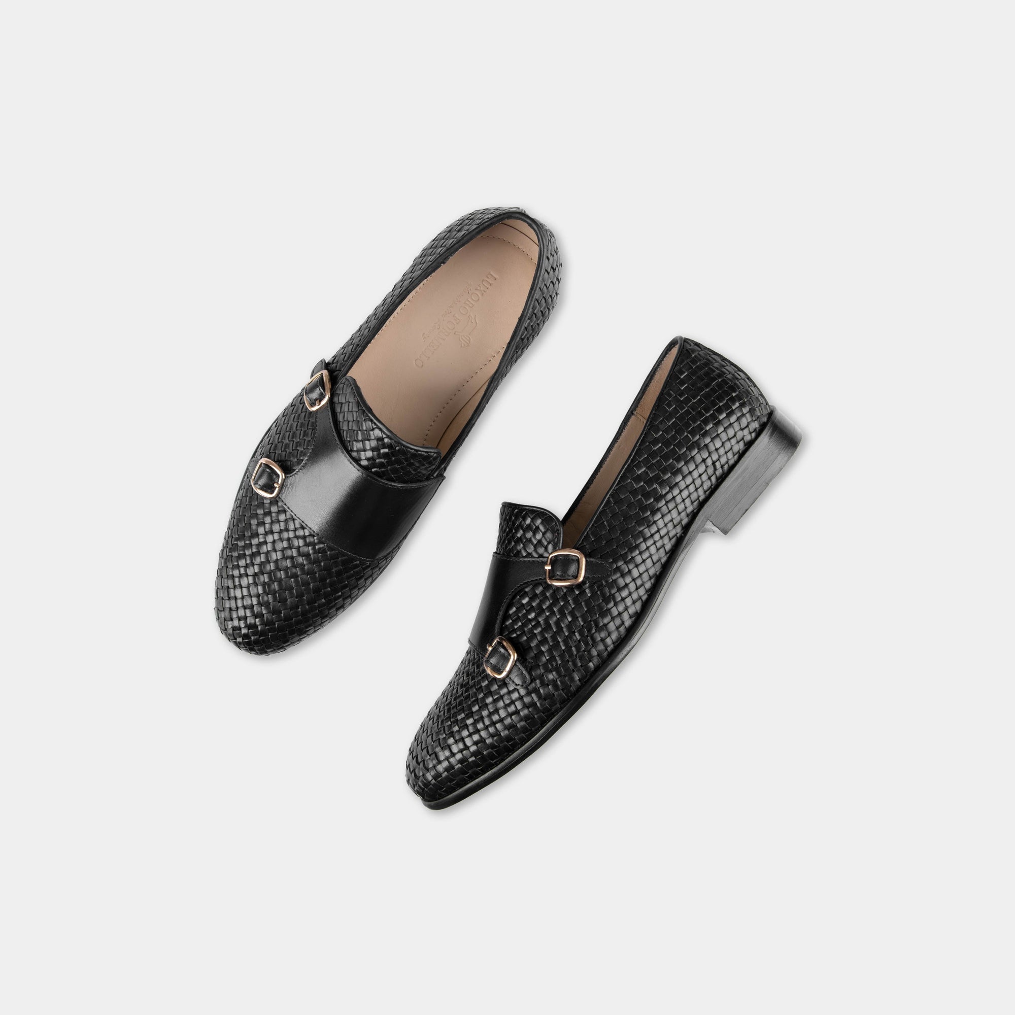 Pair of Ciro Weaved Black Leather Monk Straps with a woven design and gold buckles.