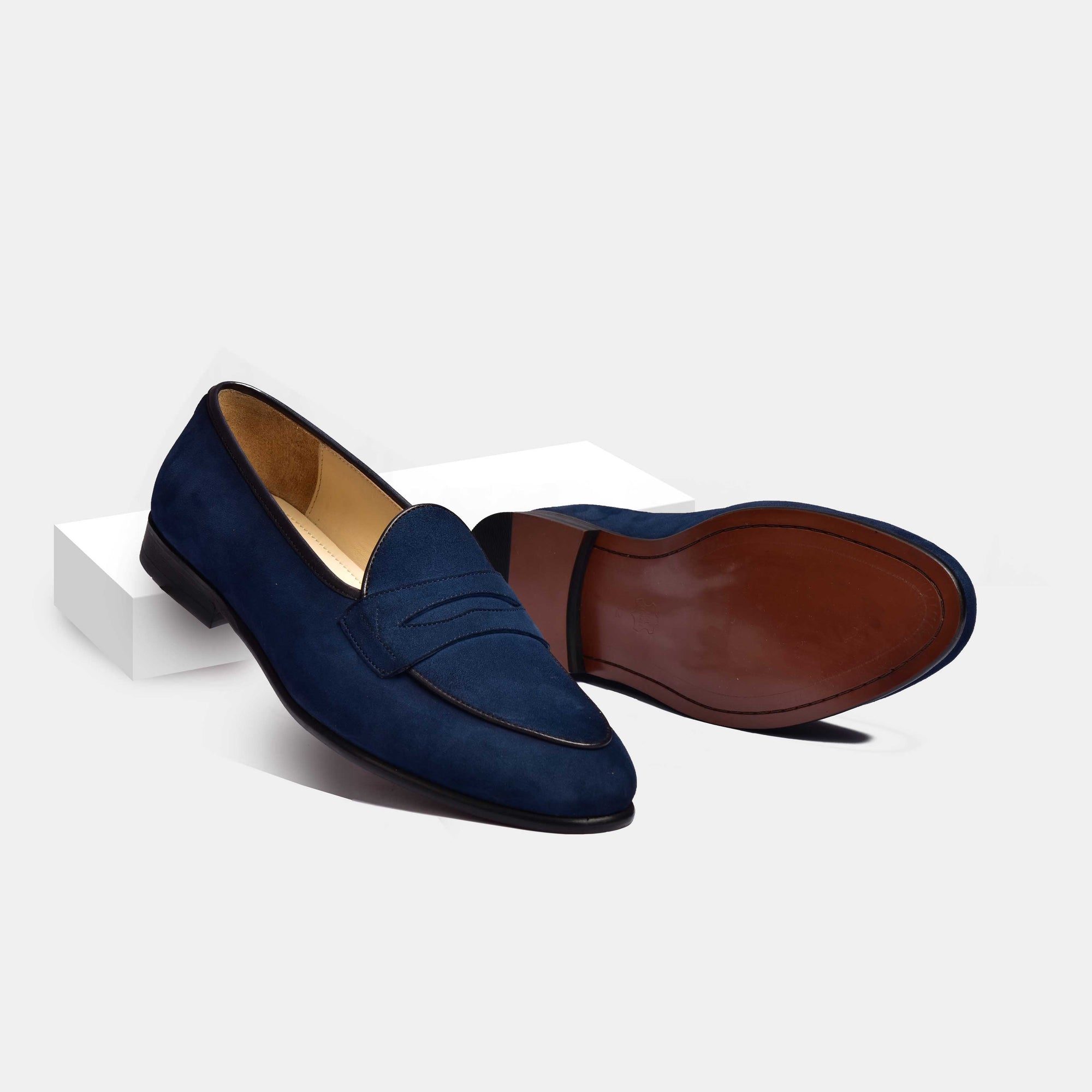 Pair of Arno Loafers in navy blue suede. The loafers feature a classic grand penny design and a sleek leather sole.