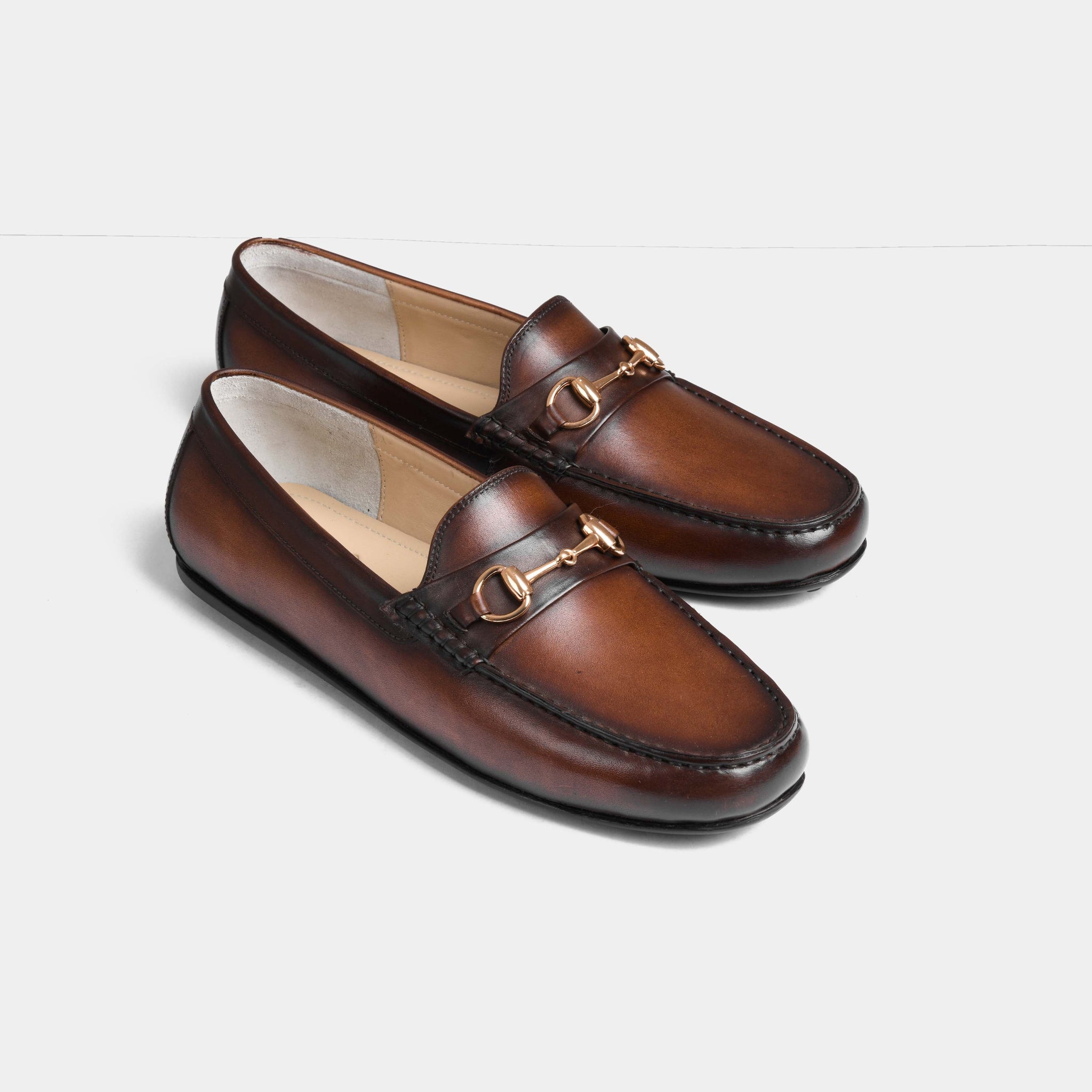 Pair of Maceo Cognac Leather Driving Loafers with gold snaffle bit detail.