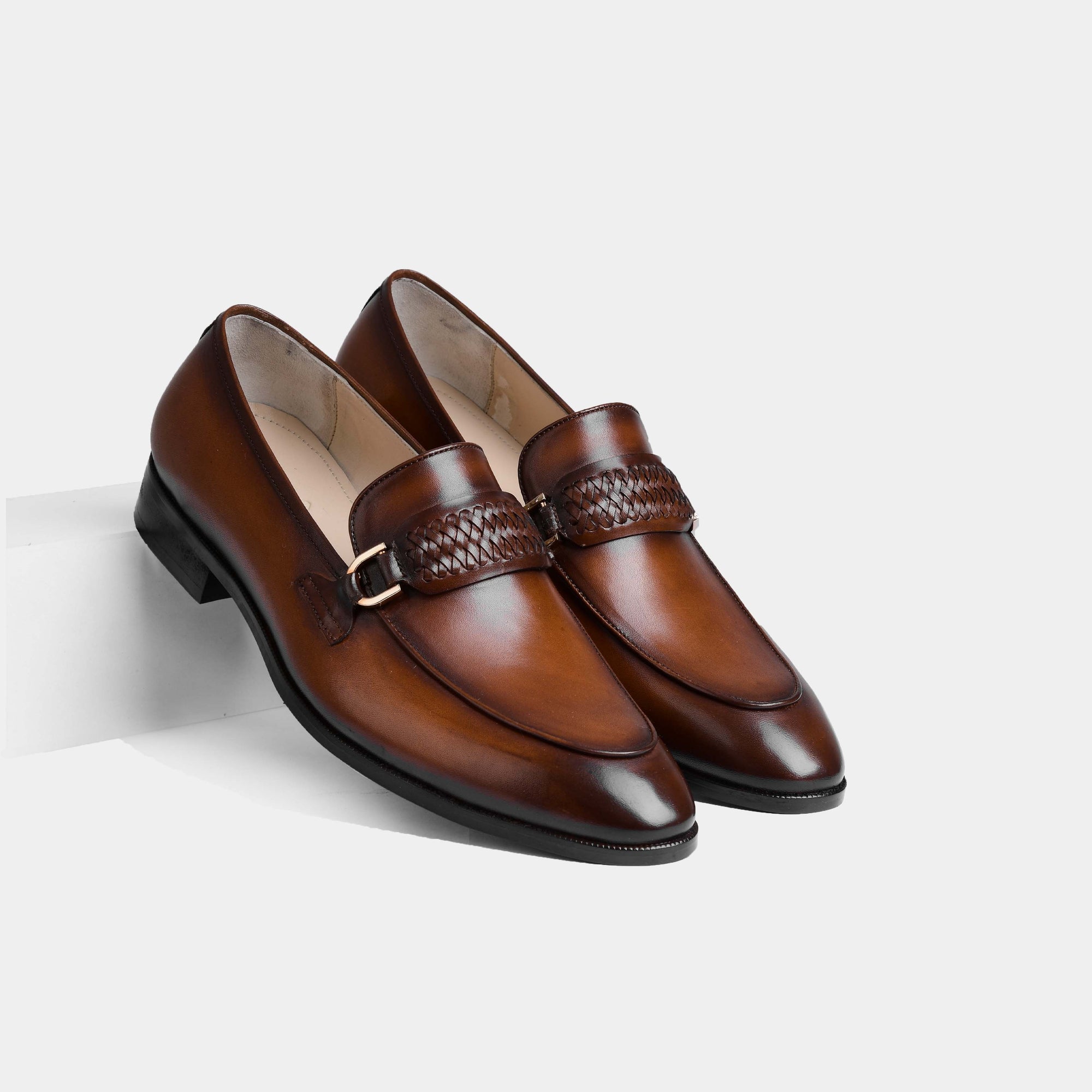 Pair of Cesar Cognac Leather Loafers with woven strap and metal buckle detail.