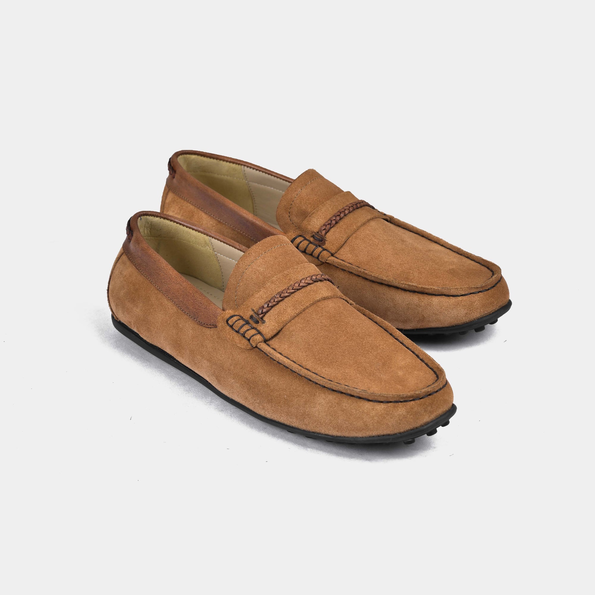 A pair of tan suede leather driving loafers with a braided strap detail across the vamp.