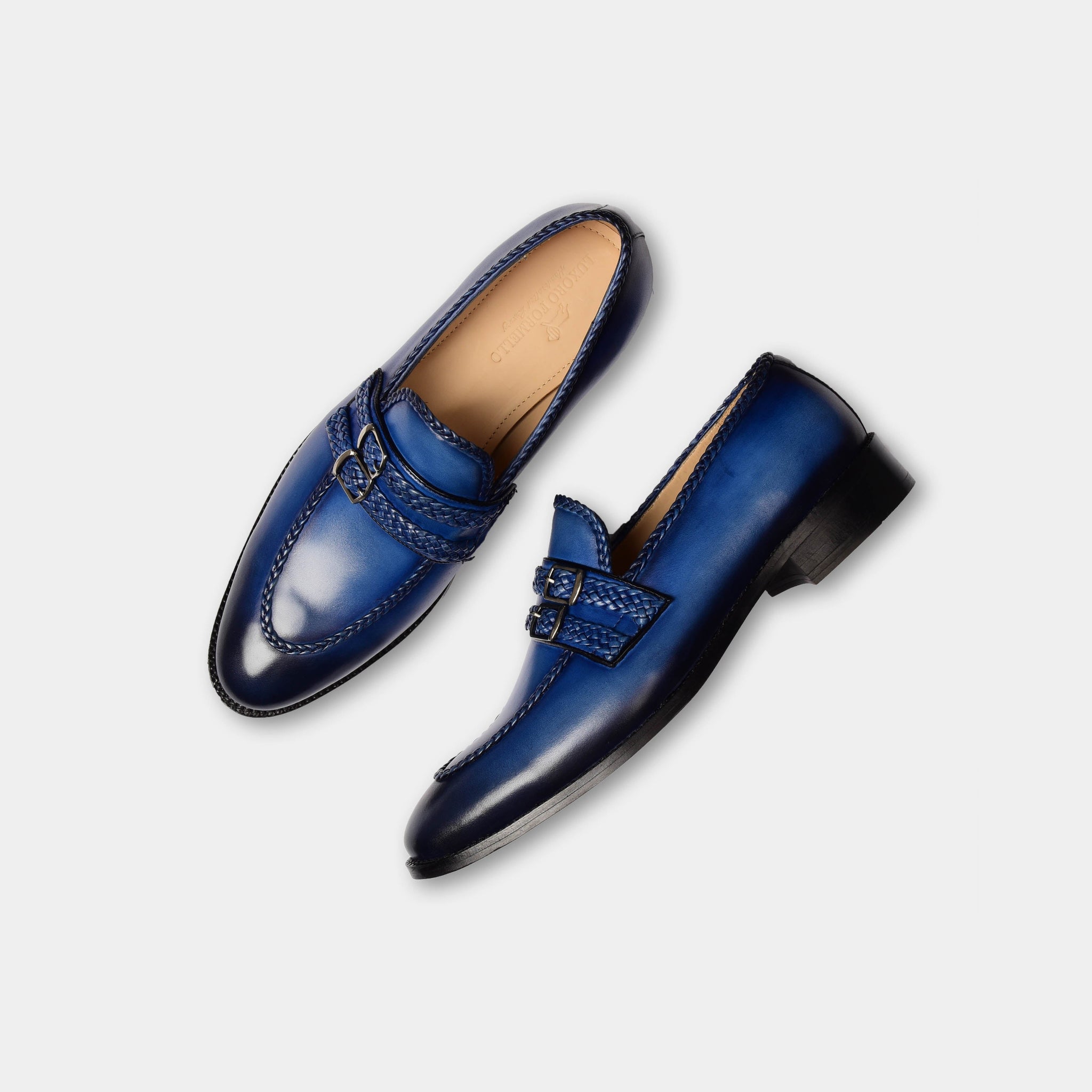 Pair of jade blue double monk strap leather loafers on a white background.