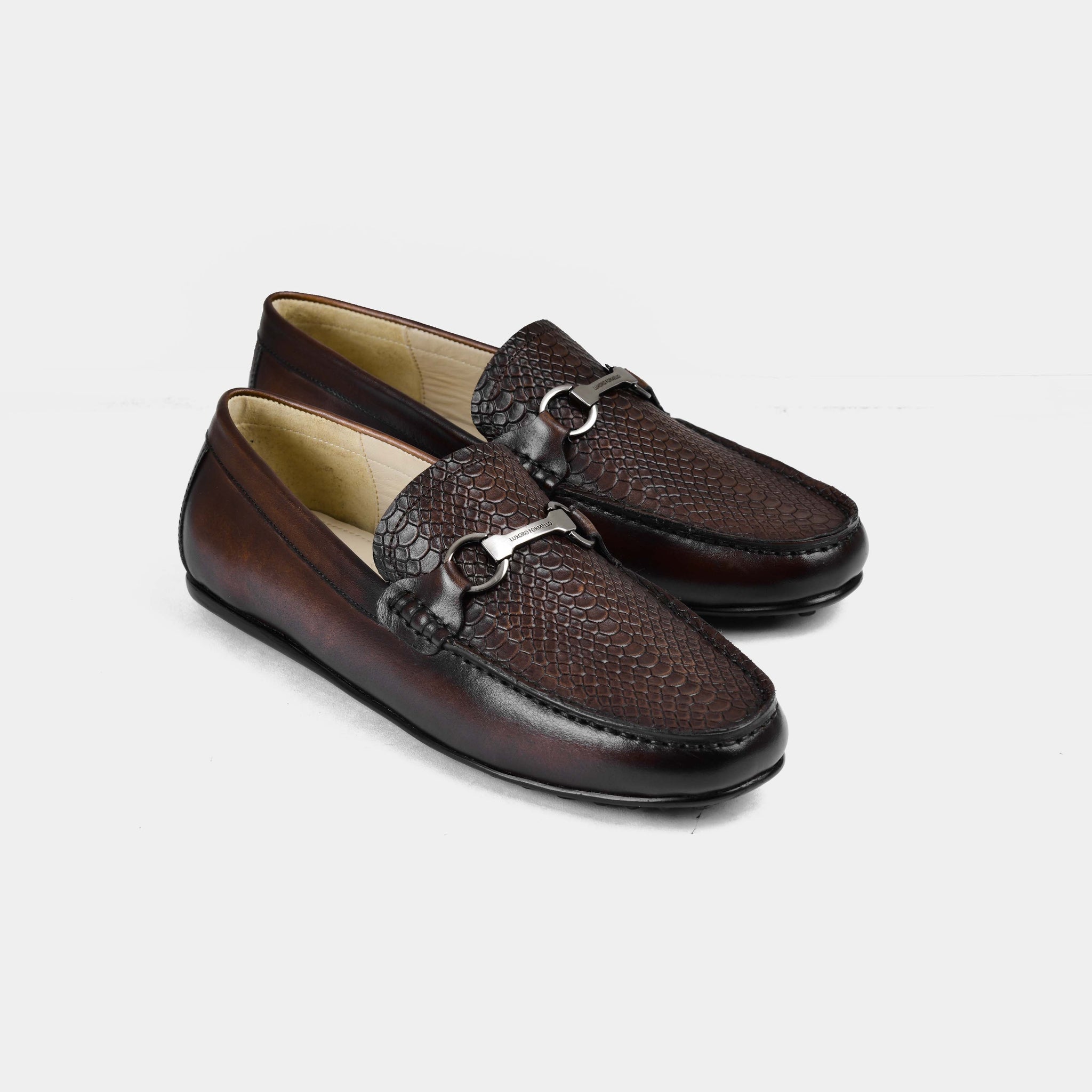 Pair of Matias Brown Leather Driving Loafers with a textured finish and silver buckle accent.