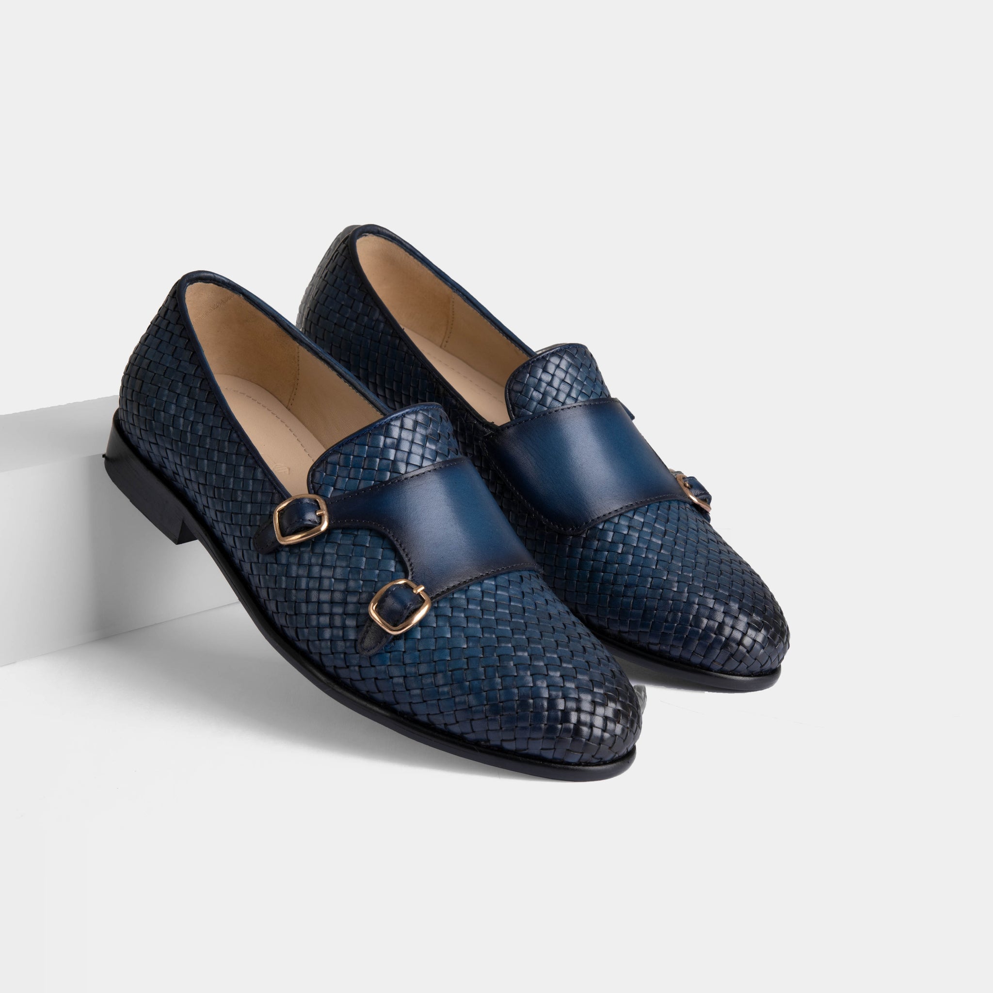 Pair of Ciro Weaved blue leather monk strap shoes with a woven design and gold buckles.