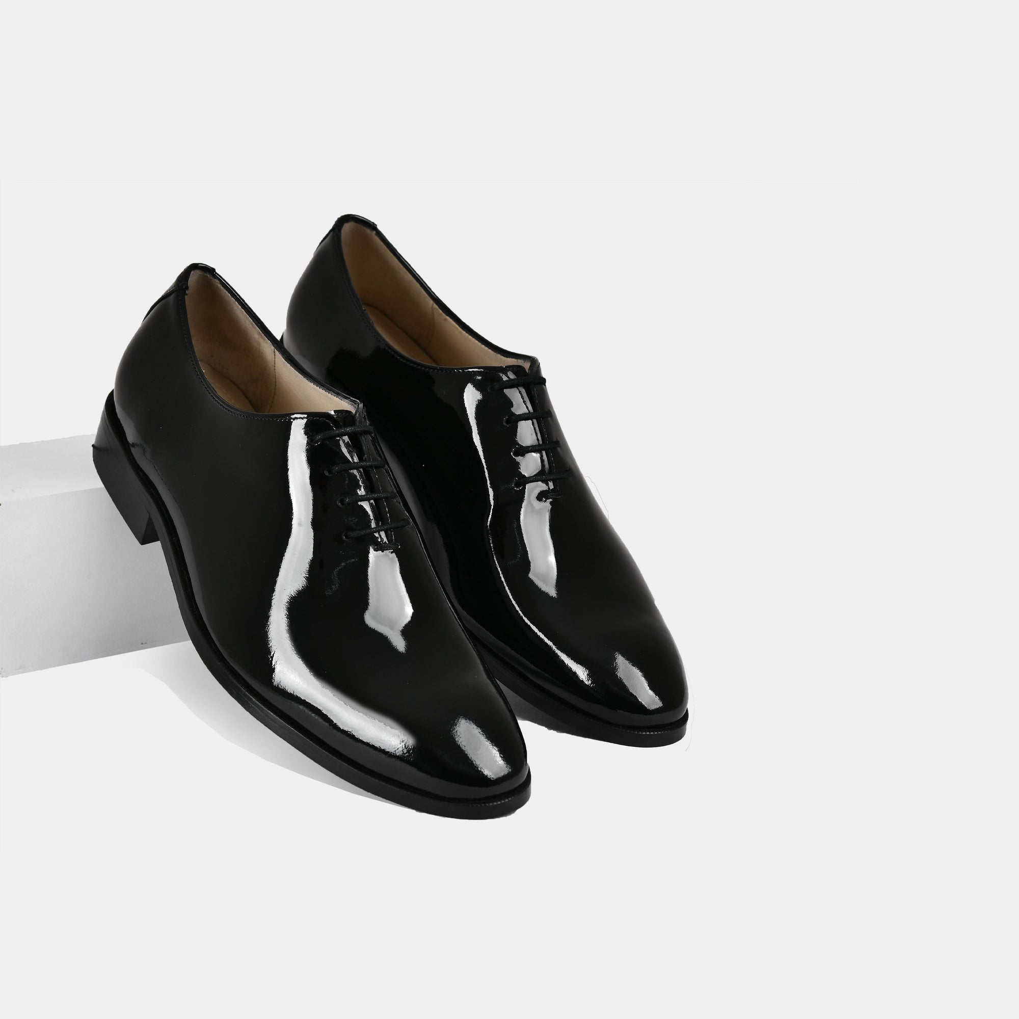 Pair of Allucio Wholecut Leather Laceups in black, showcasing their sleek, polished design.