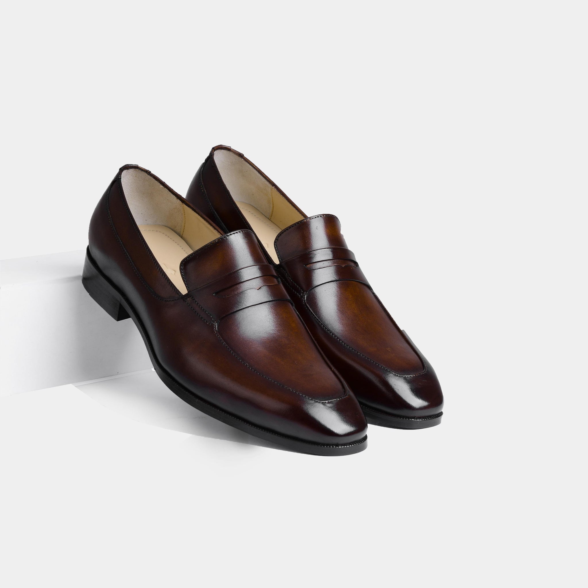 Pair of Andres Brown Loafers, polished brown leather slip-on shoes with a penny loafer strap.