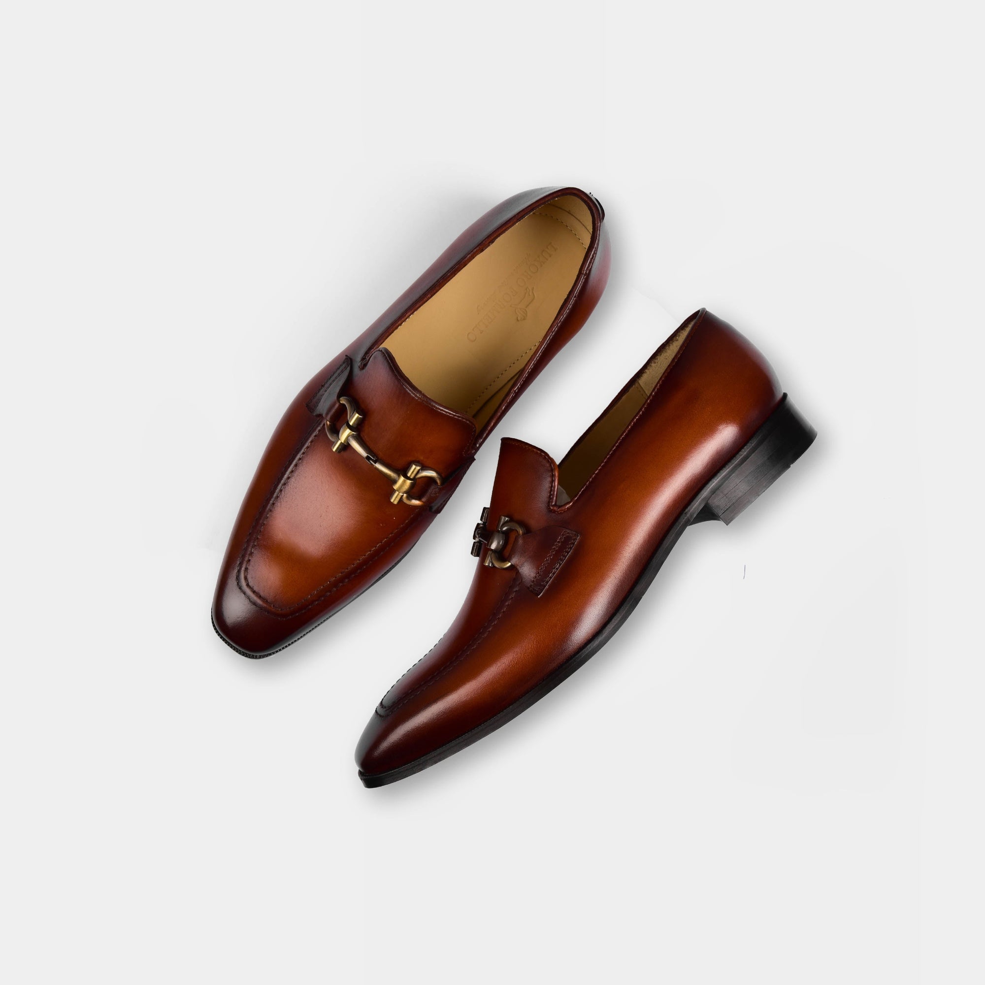 A pair of Dario Tan Leather Loafers, featuring a sleek tan leather finish and a stylish metal buckle accent.