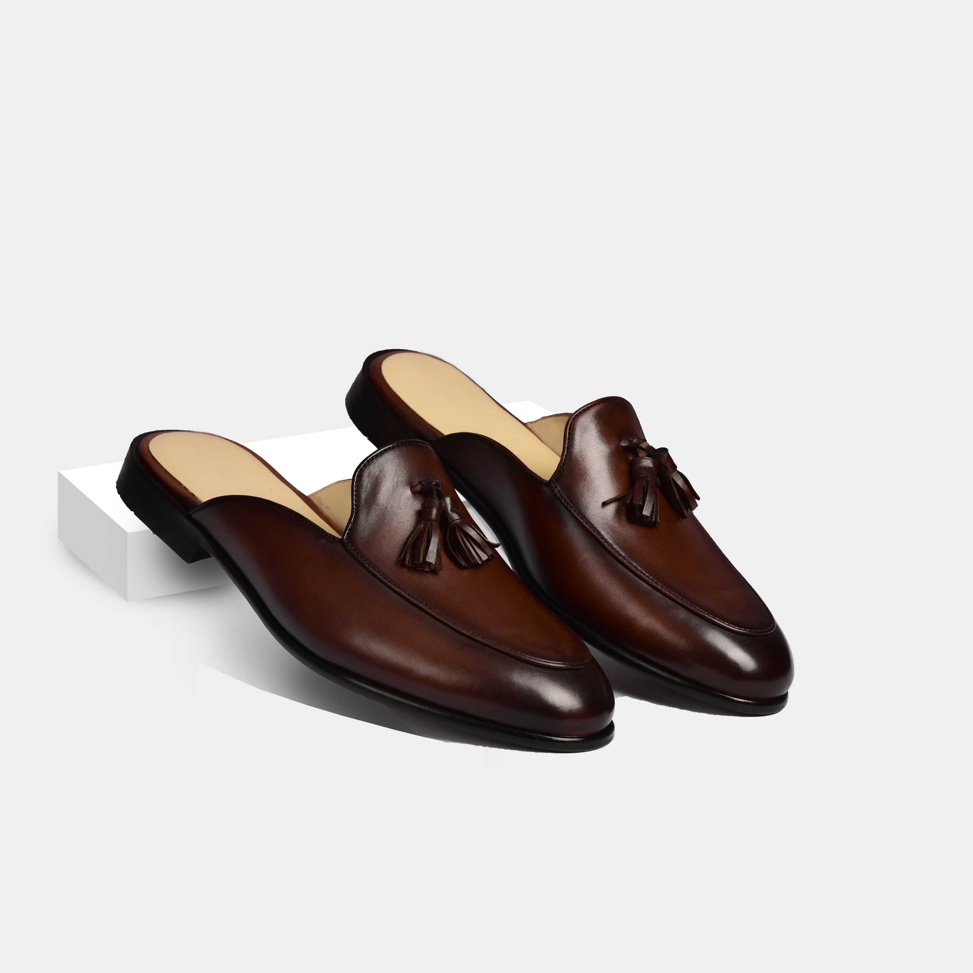 Pair of Arno brown leather formal mules with tassel detail.