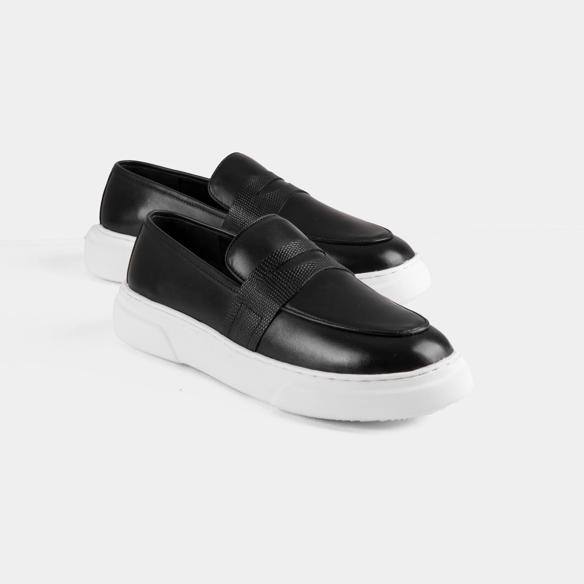 A pair of Saul Black Leather Sneakers with a sleek, black leather upper, detailed stitching, and a modern white platform sole.