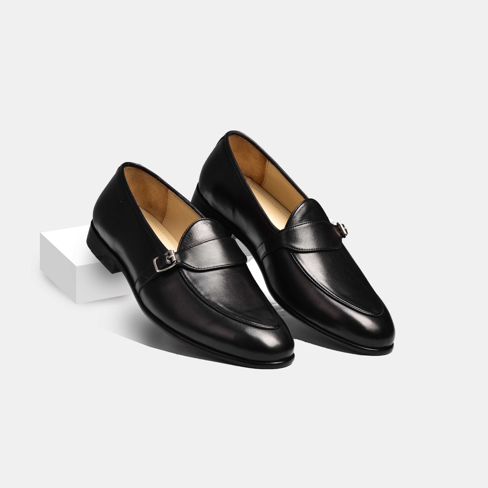 Pair of men's black leather Arno loafers with a single strap and buckle detail.