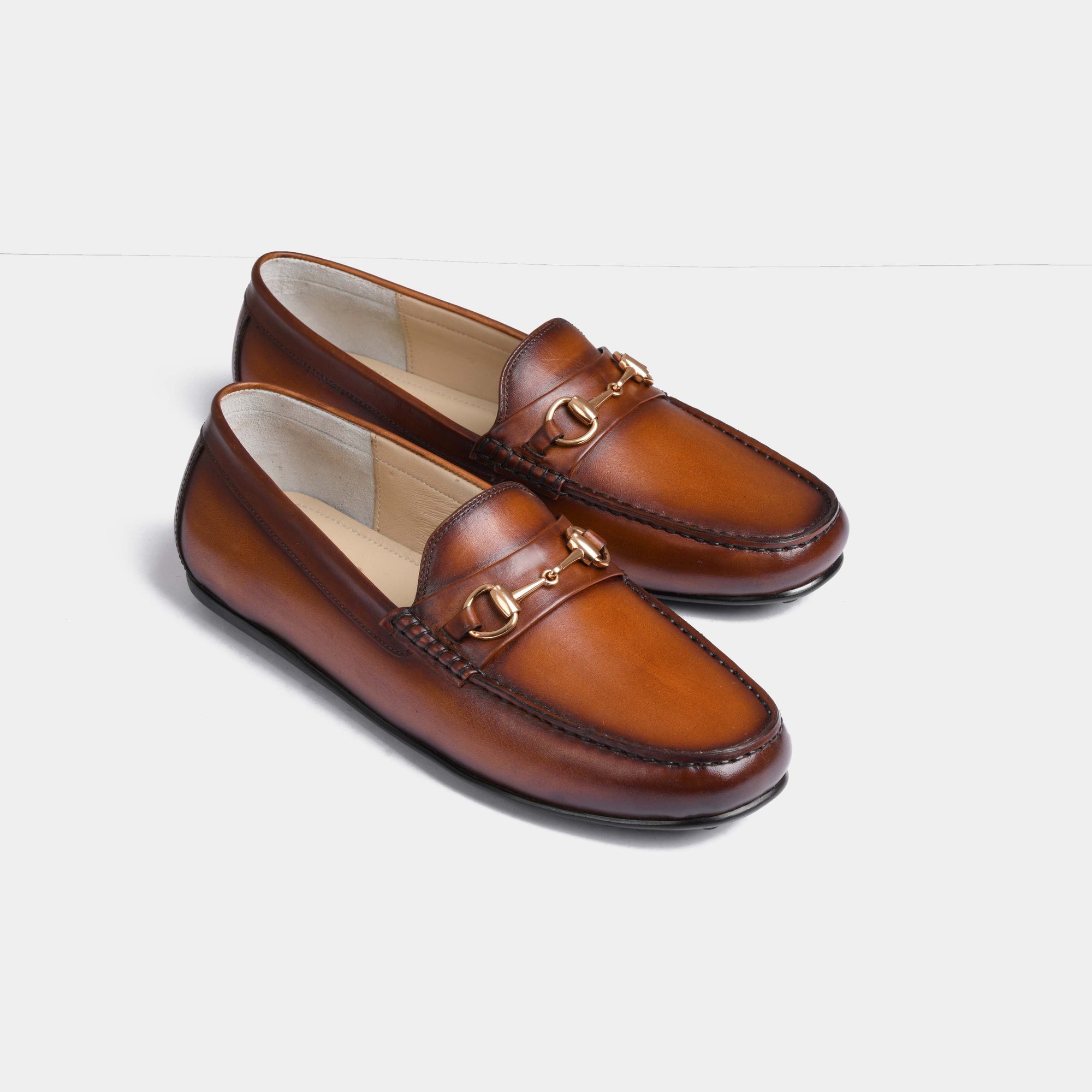 A pair of Marco Tan Leather Driving Loafers with gold snaffle bit hardware.