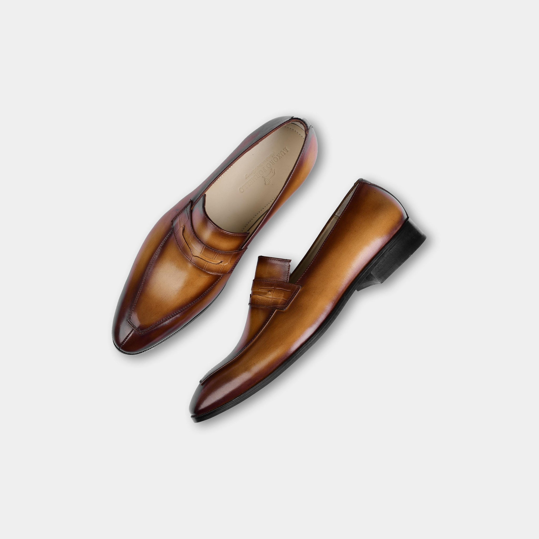 Pair of Lucero Walnut Leather Loafers, showcasing their rich brown leather uppers and classic penny loafer style.