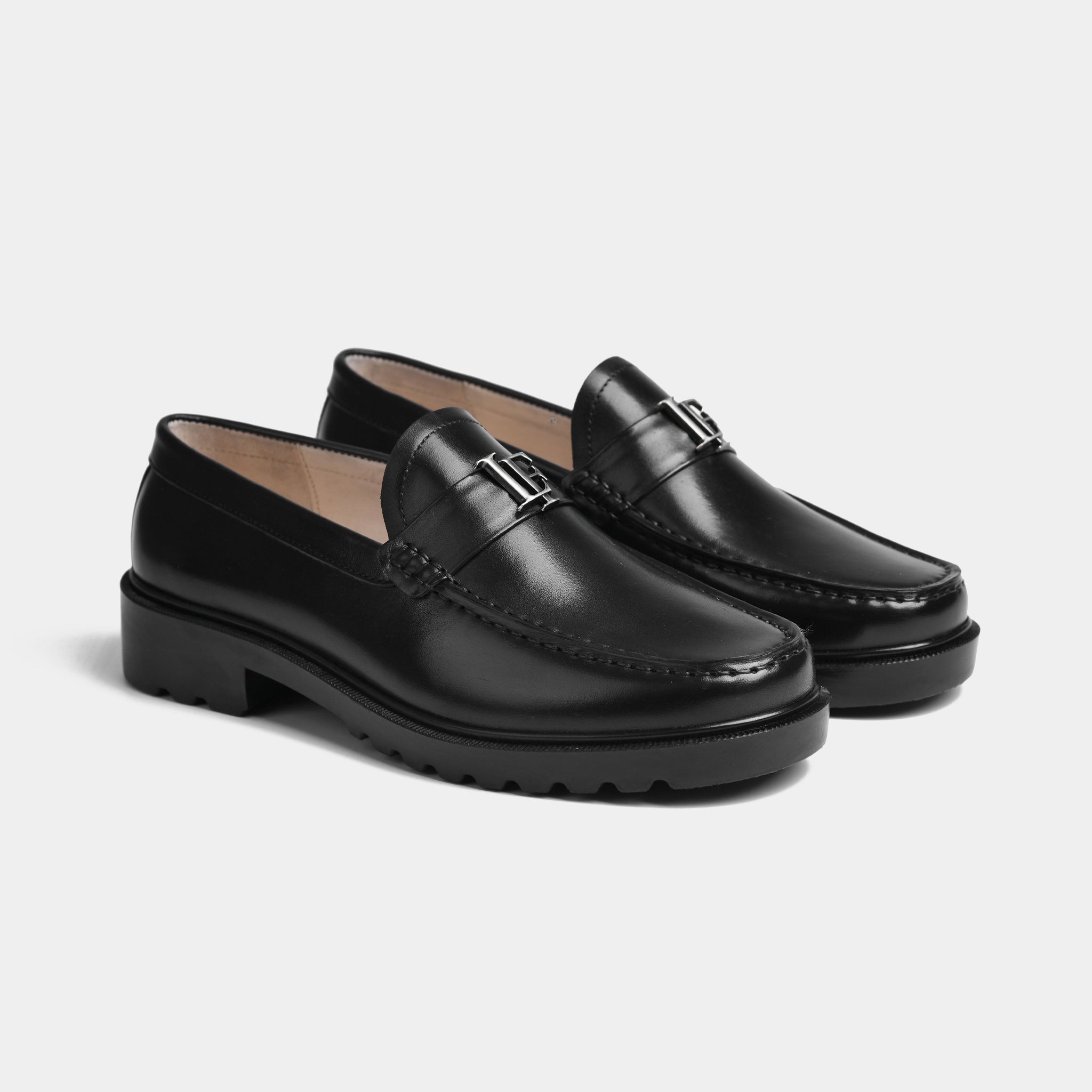 A pair of Black Lf Timeless Leather Loafers in black with a silver metal accent on the strap.