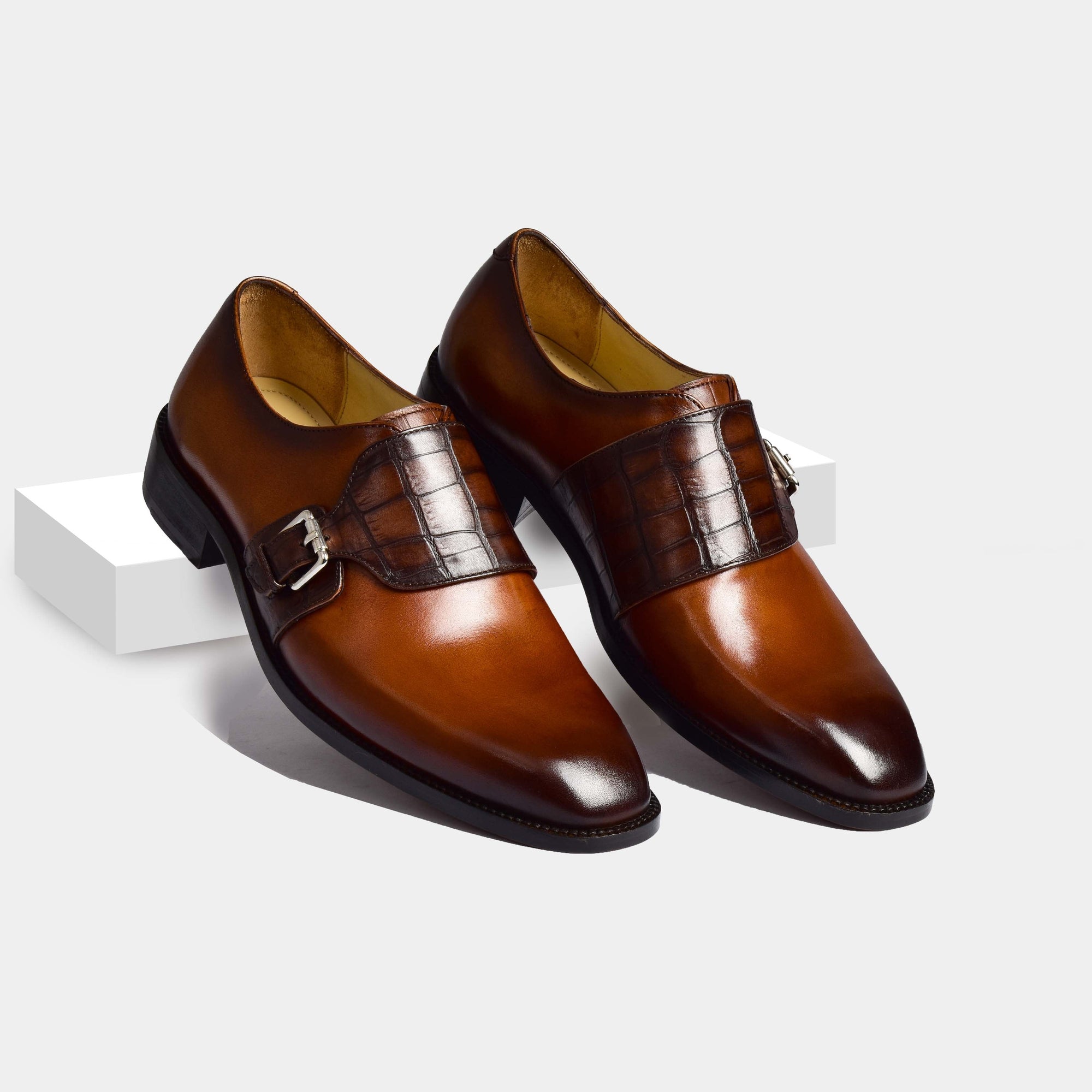 Pair of Jonathan Cognac Single Leather Monk Strap shoes in brown leather with a crocodile embossed strap and buckle detail.