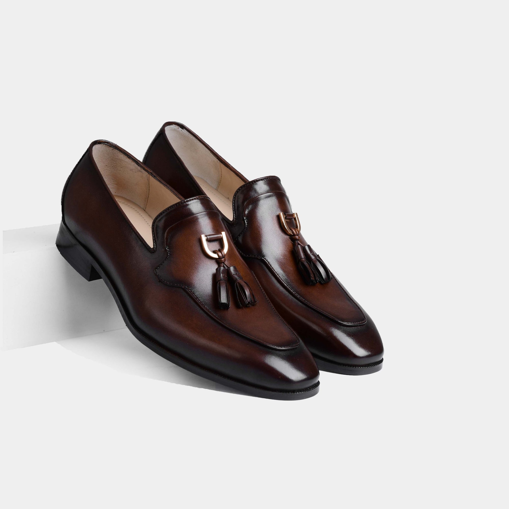 A pair of Atilio Brown Leather Loafers with gold buckle tassels.