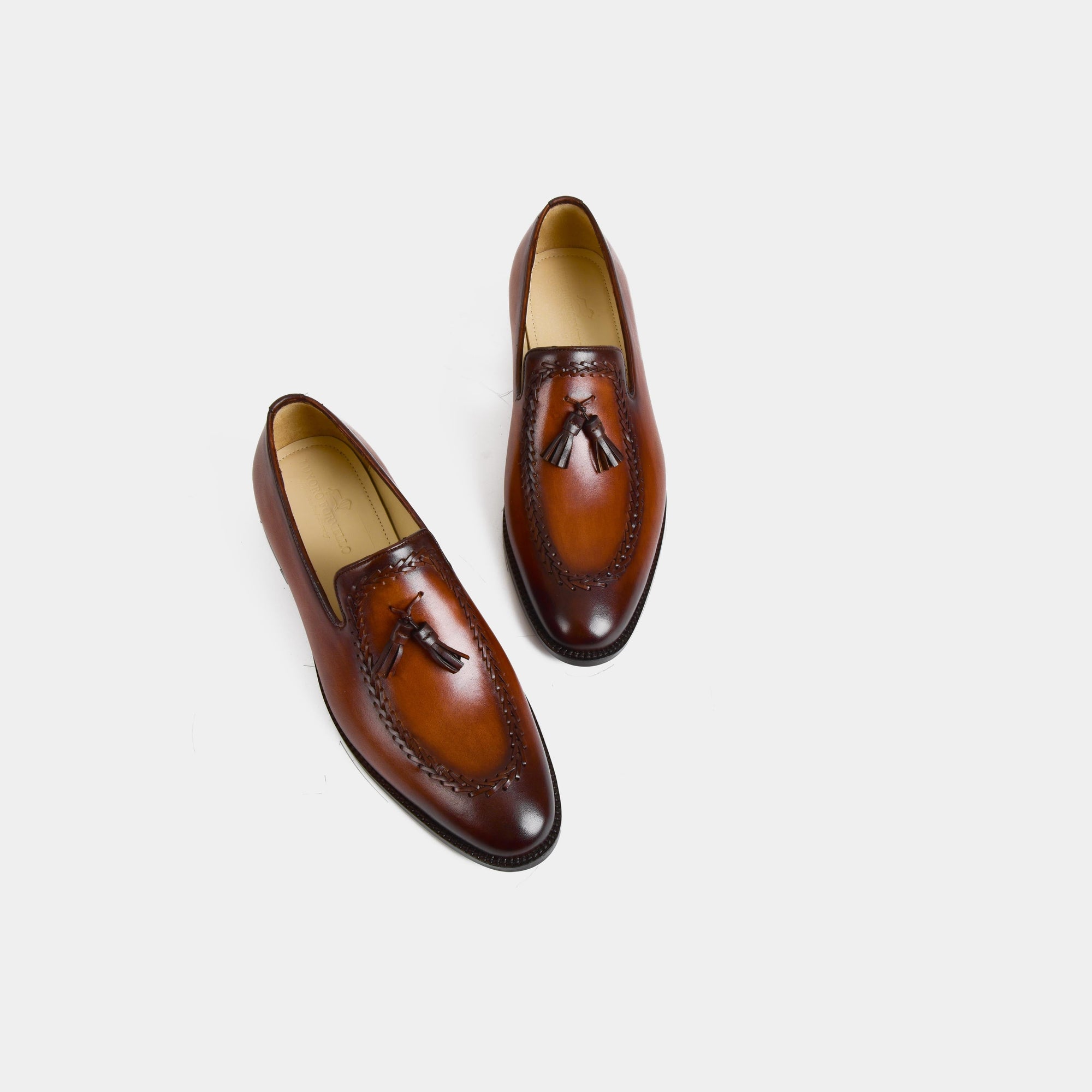 A pair of Peter Norwan Leather Loafers in brown leather with decorative stitching and tassels.