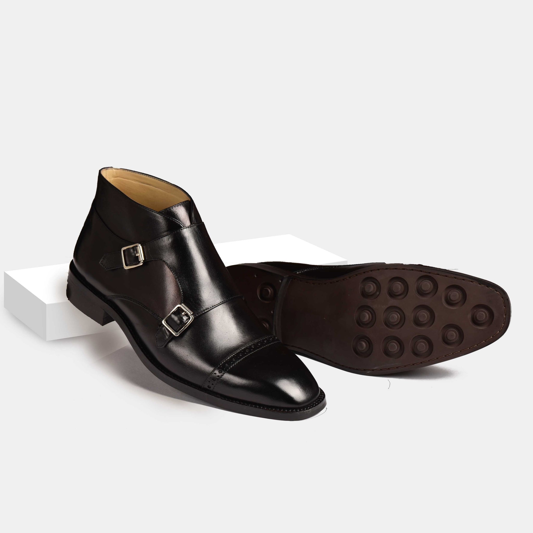 A pair of Alfred Double Monk Boots in black leather, showcasing the double monk strap and cap-toe detailing.