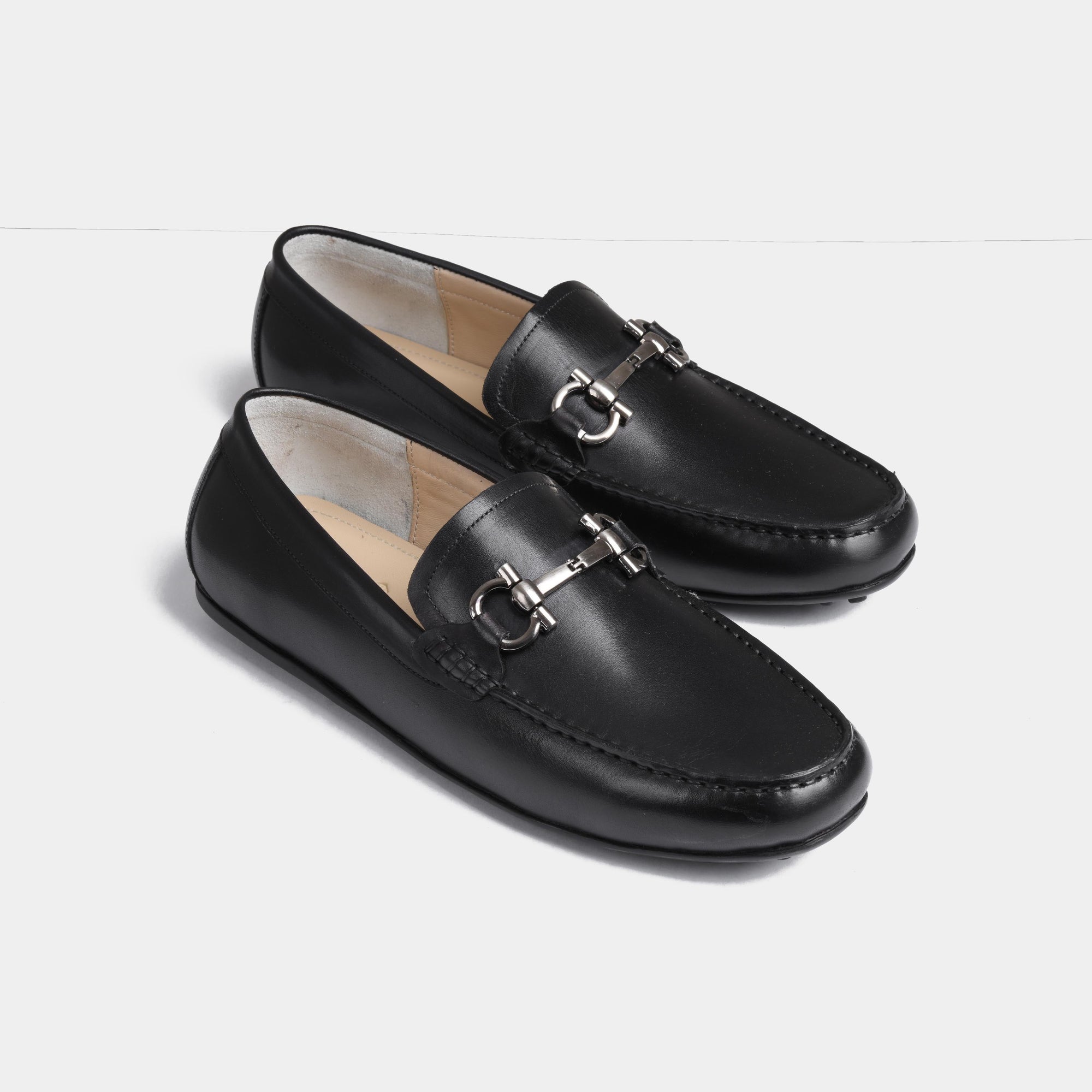 Pair of Helio Black Leather Driving Loafers with silver buckle detail.