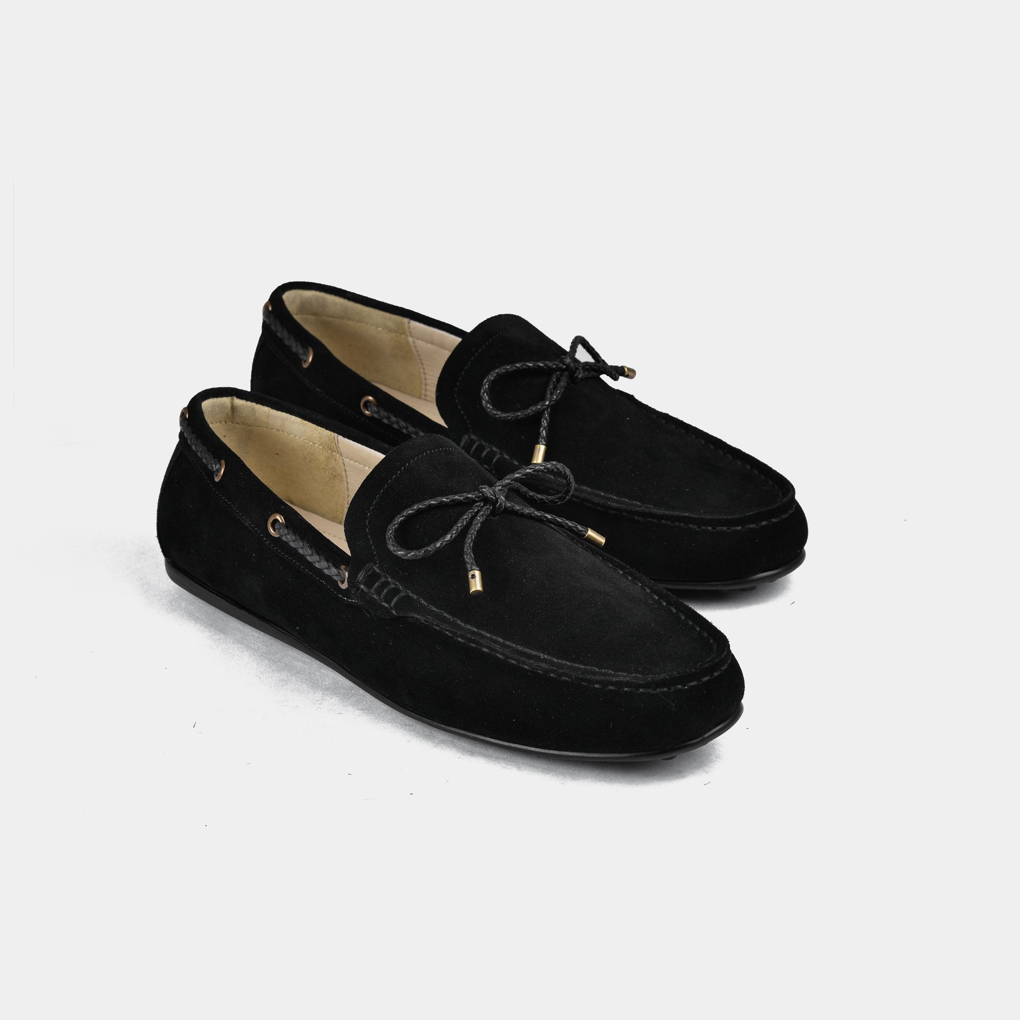 A pair of black suede leather driving loafers with a stylish knotted lace detail.