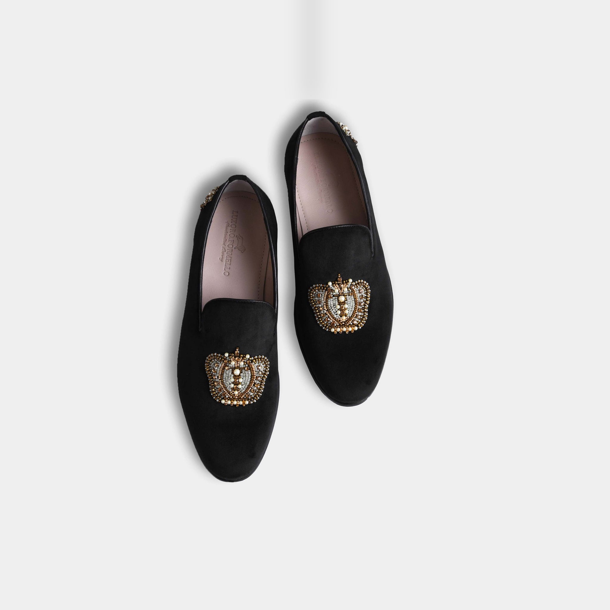 Pair of black Elizar slip-on shoes with intricate gold and pearl crown embroidery on the vamp.