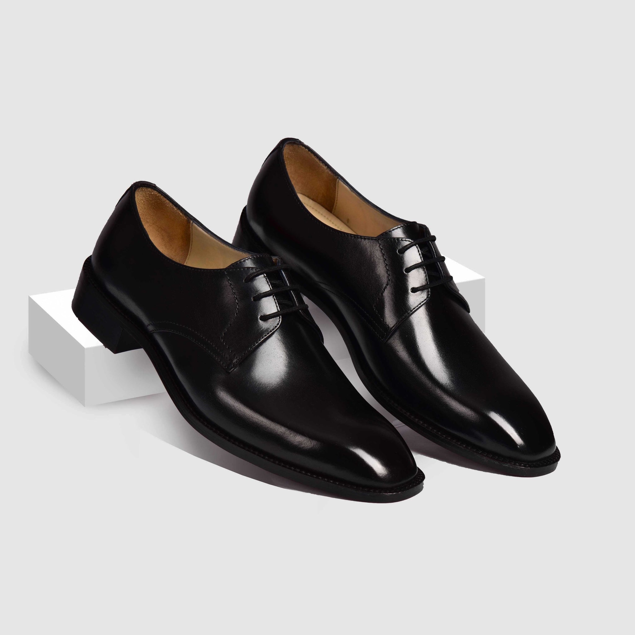 A pair of Reuben Lincoln Leather Laceups in black, showcasing their polished leather upper and classic lace-up closure.