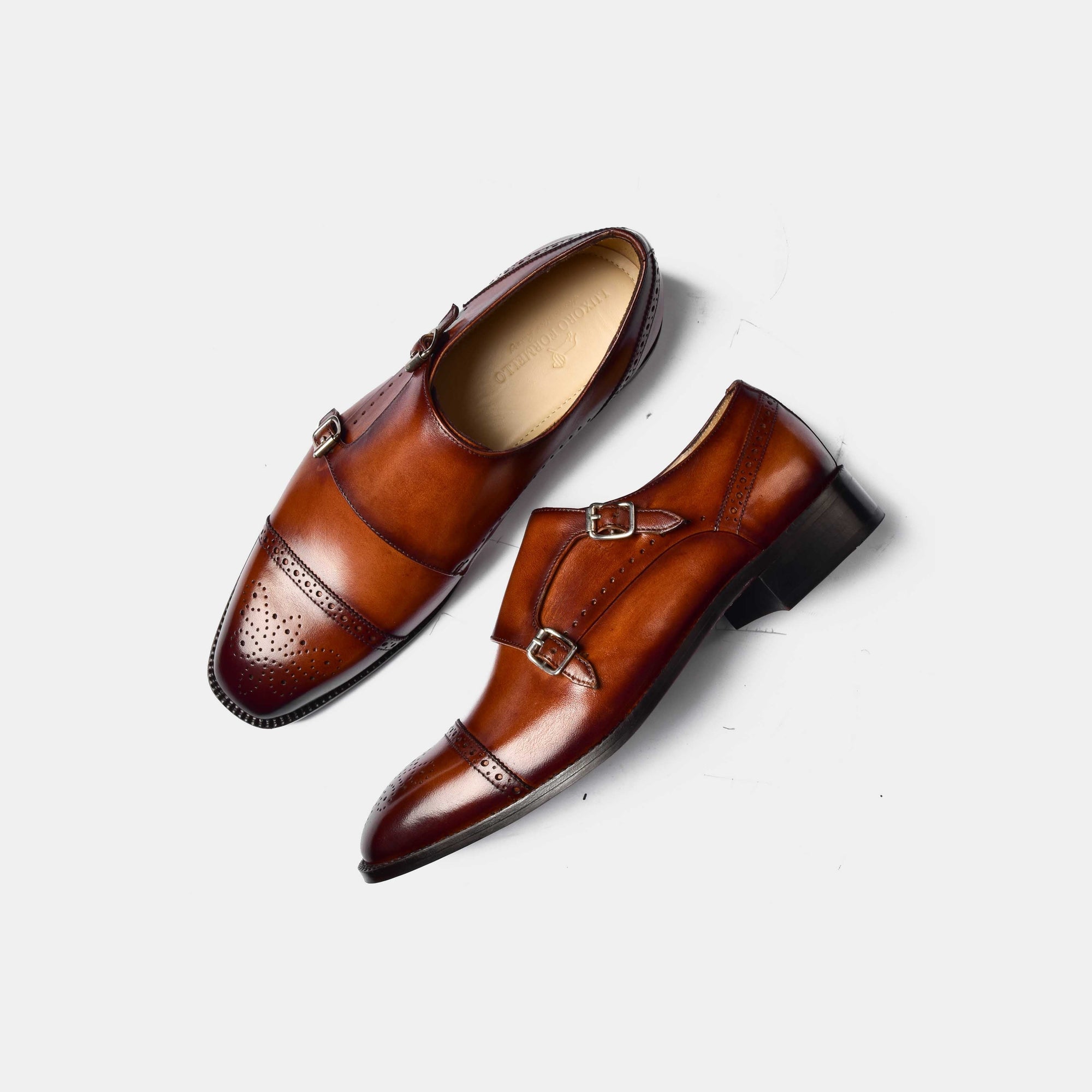 A pair of Henry Tan Double Leather Monk Straps in brown, showcasing the brogue detailing and double buckle closure.