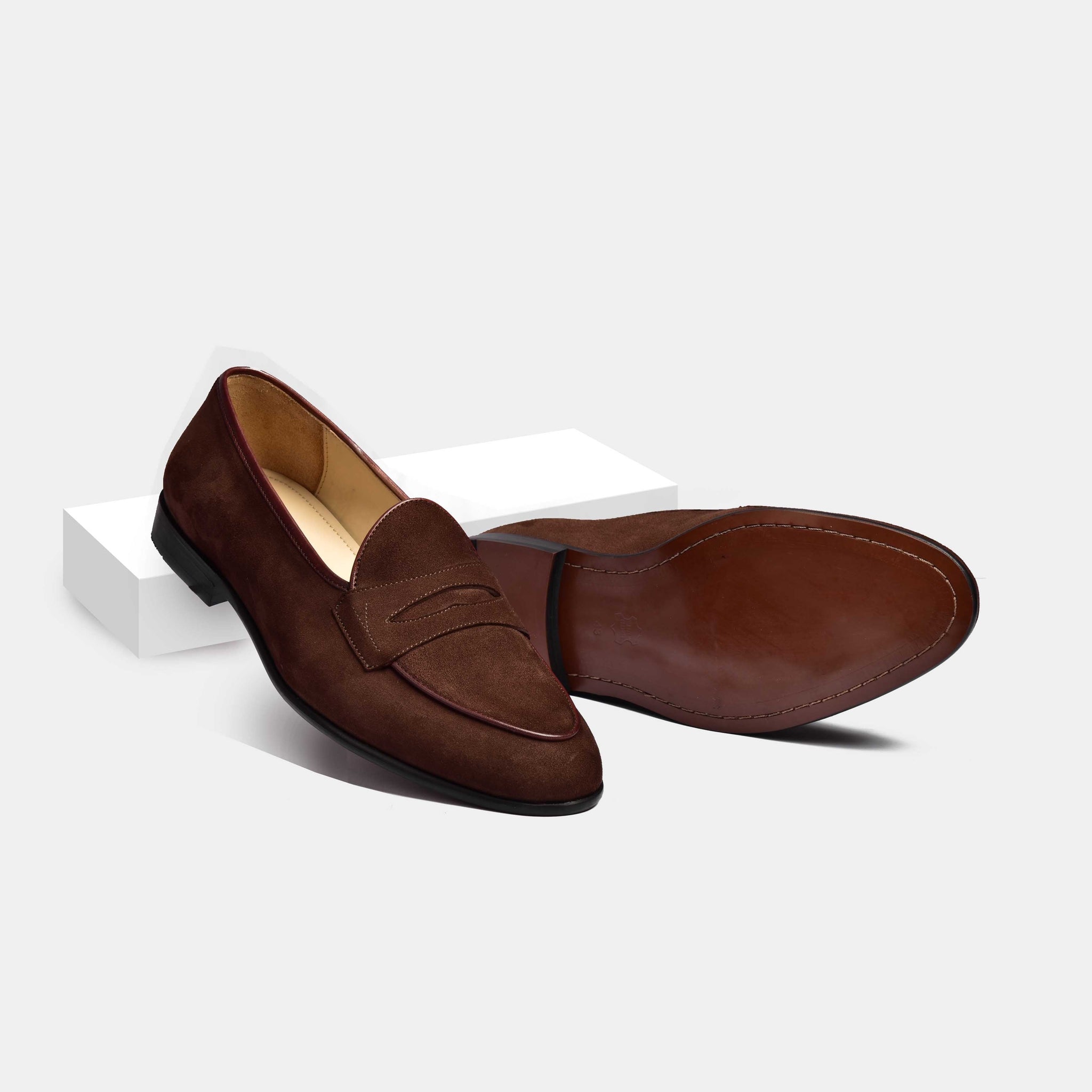 A pair of brown suede Arno loafers with a grand penny detail, showcasing their classic design and rich texture.