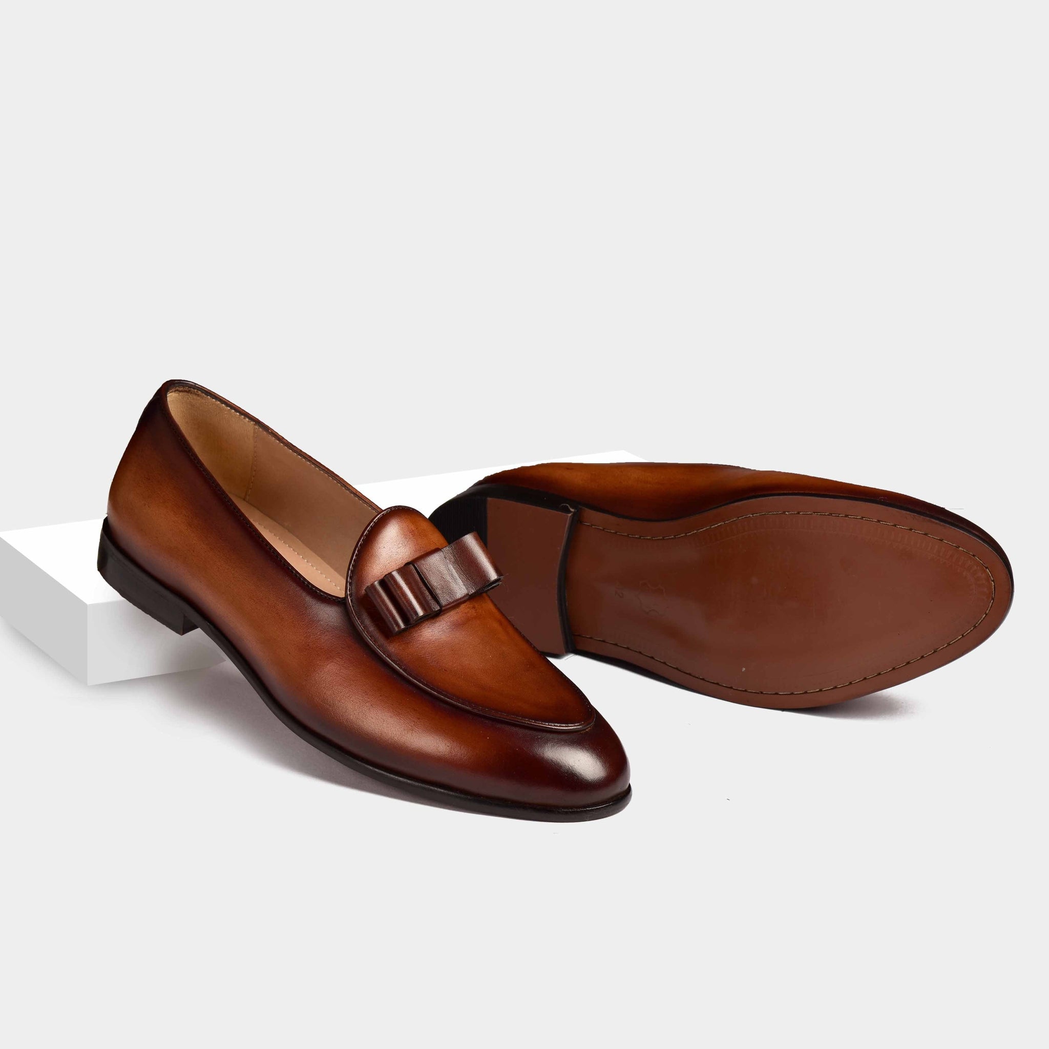 Pair of brown patina Arno Loafers with a stylish bow-tie silhouette, showcasing their premium leather construction.