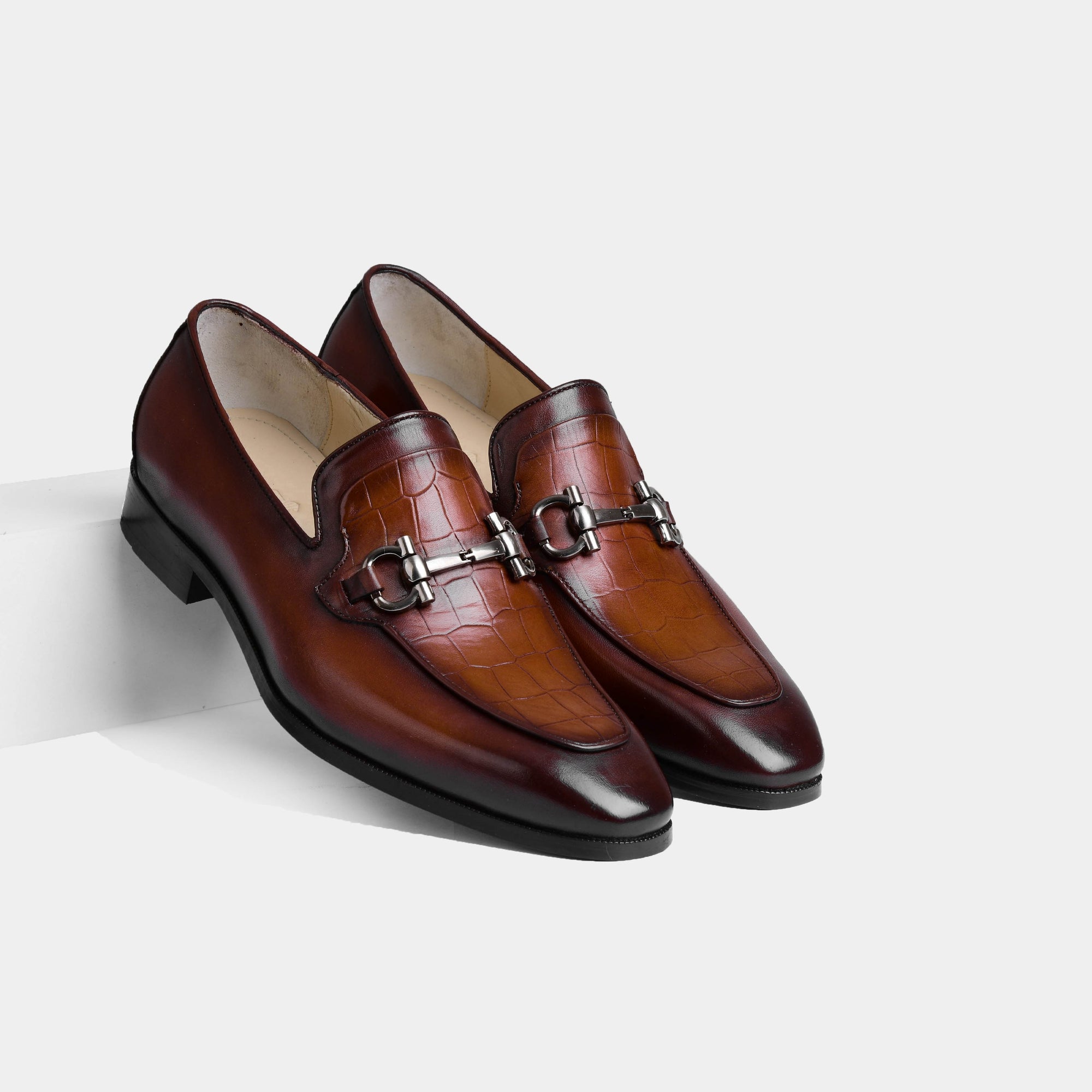 Pair of men's Gior cognac leather loafers with crocodile-embossed detail, brushed metal trim, and hand-stitched finishing.