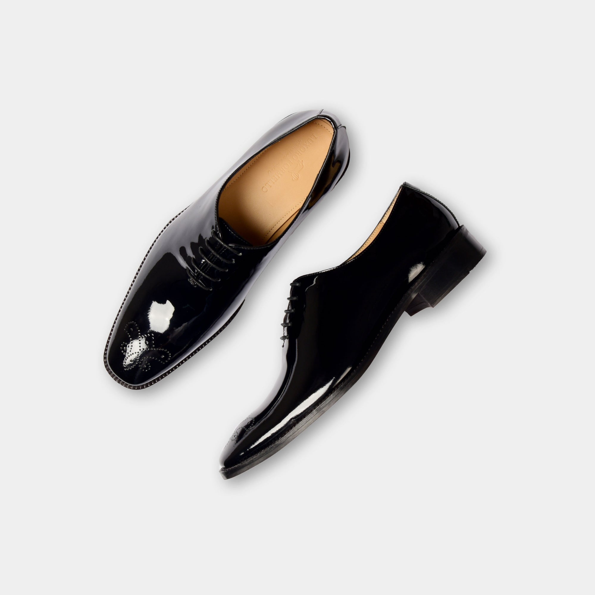 Pair of Oscar Noir Lace Ups, black patent leather dress shoes with broguing detail.