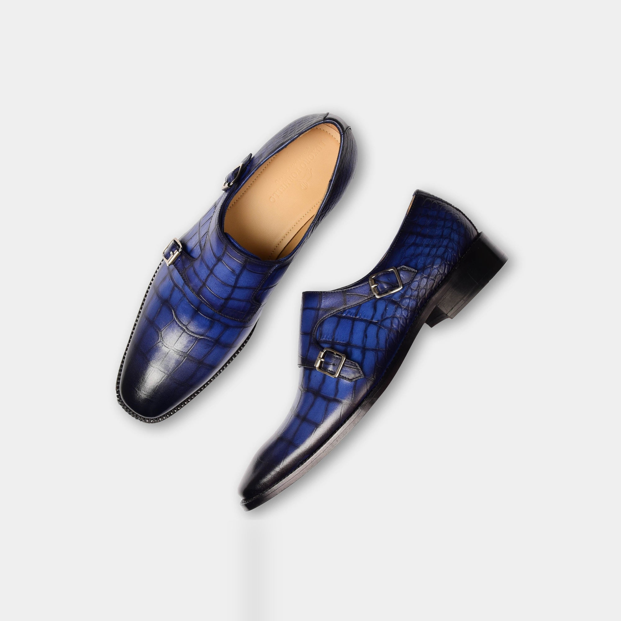 Pair of blue Michael Niel Leather Monk Strap shoes with a textured finish, shown from a top-down angle.