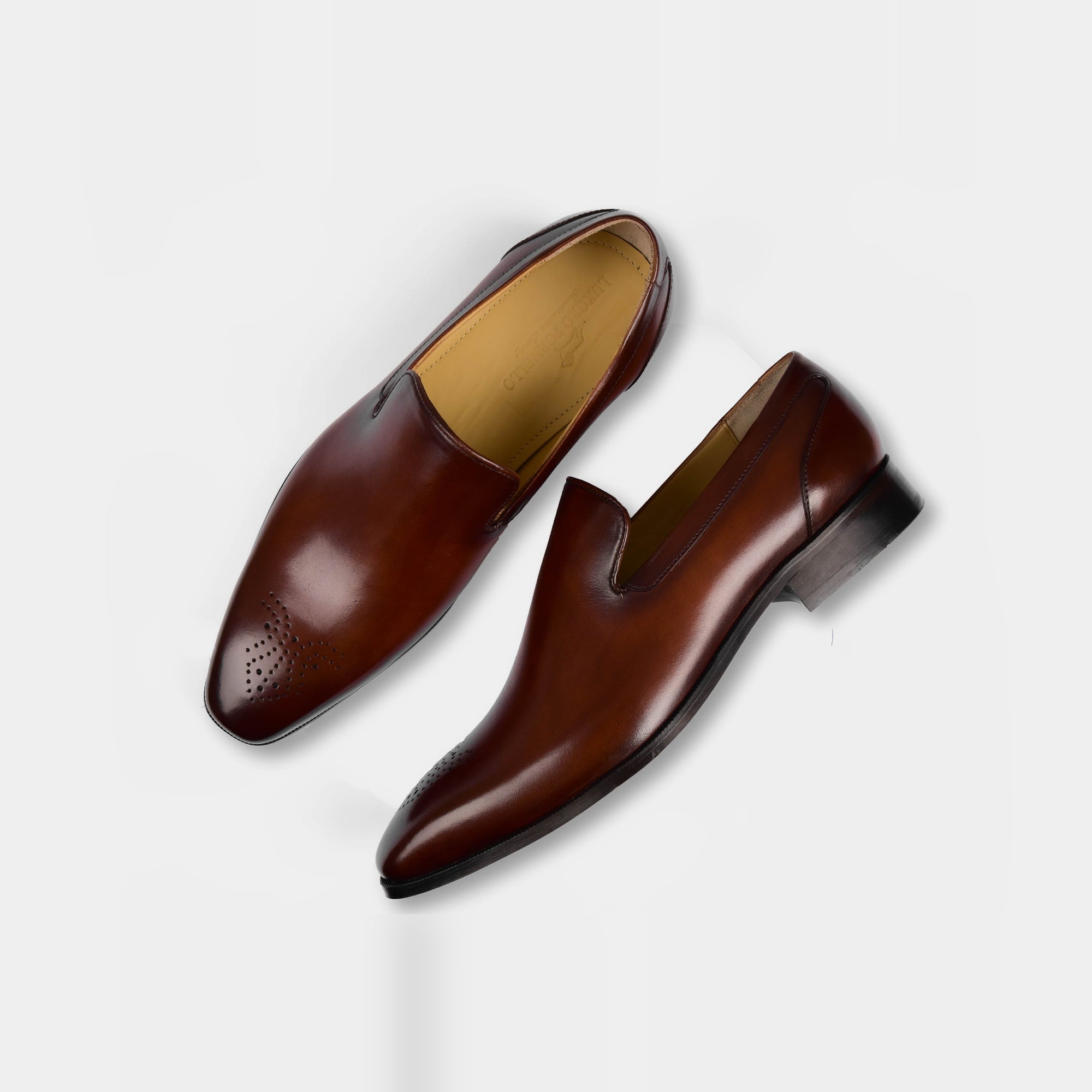 Pair of Charles Choc Leather Loafers with brogue detailing on a white background.