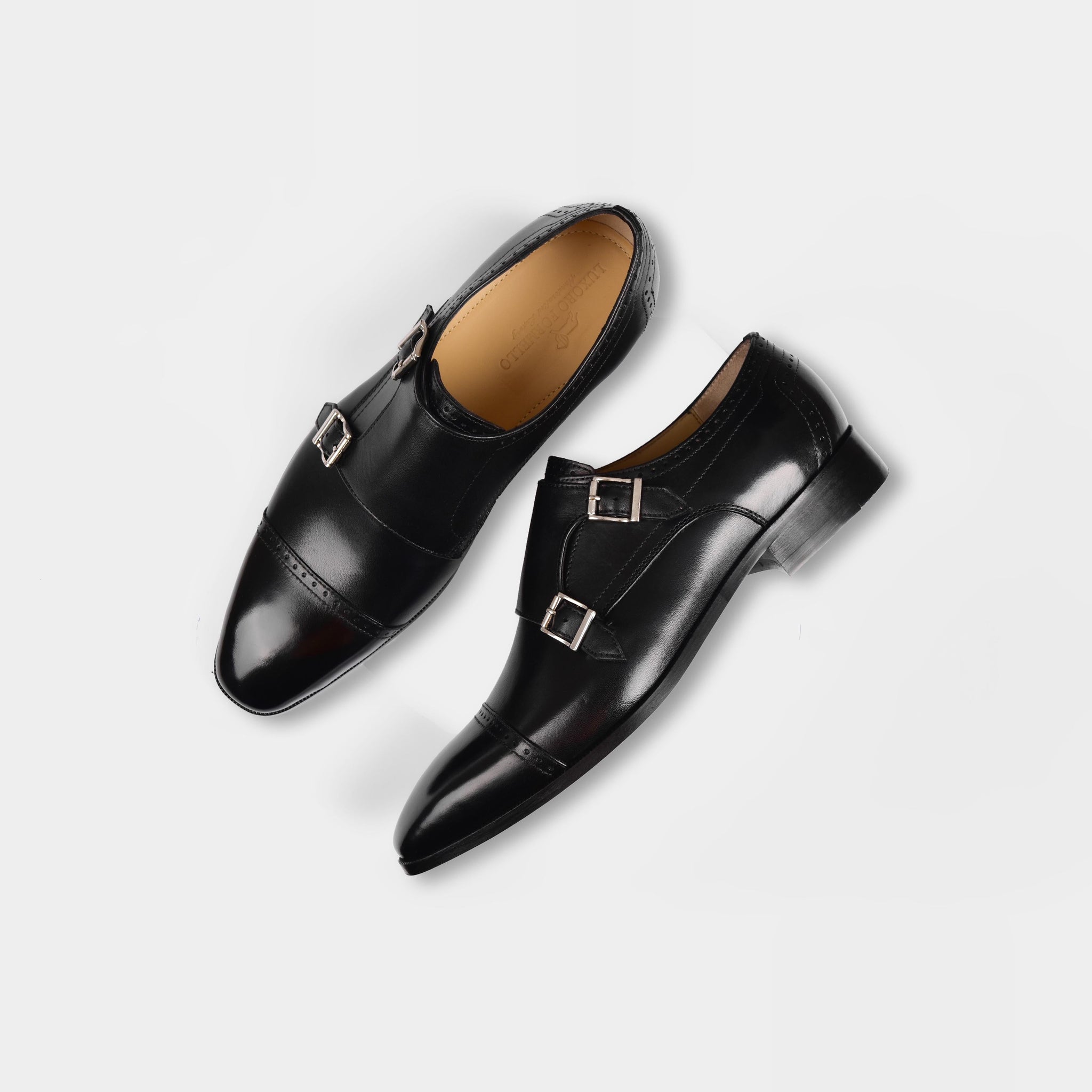 A pair of Nacario Black Monk Straps dress shoes with silver buckles on a white background.