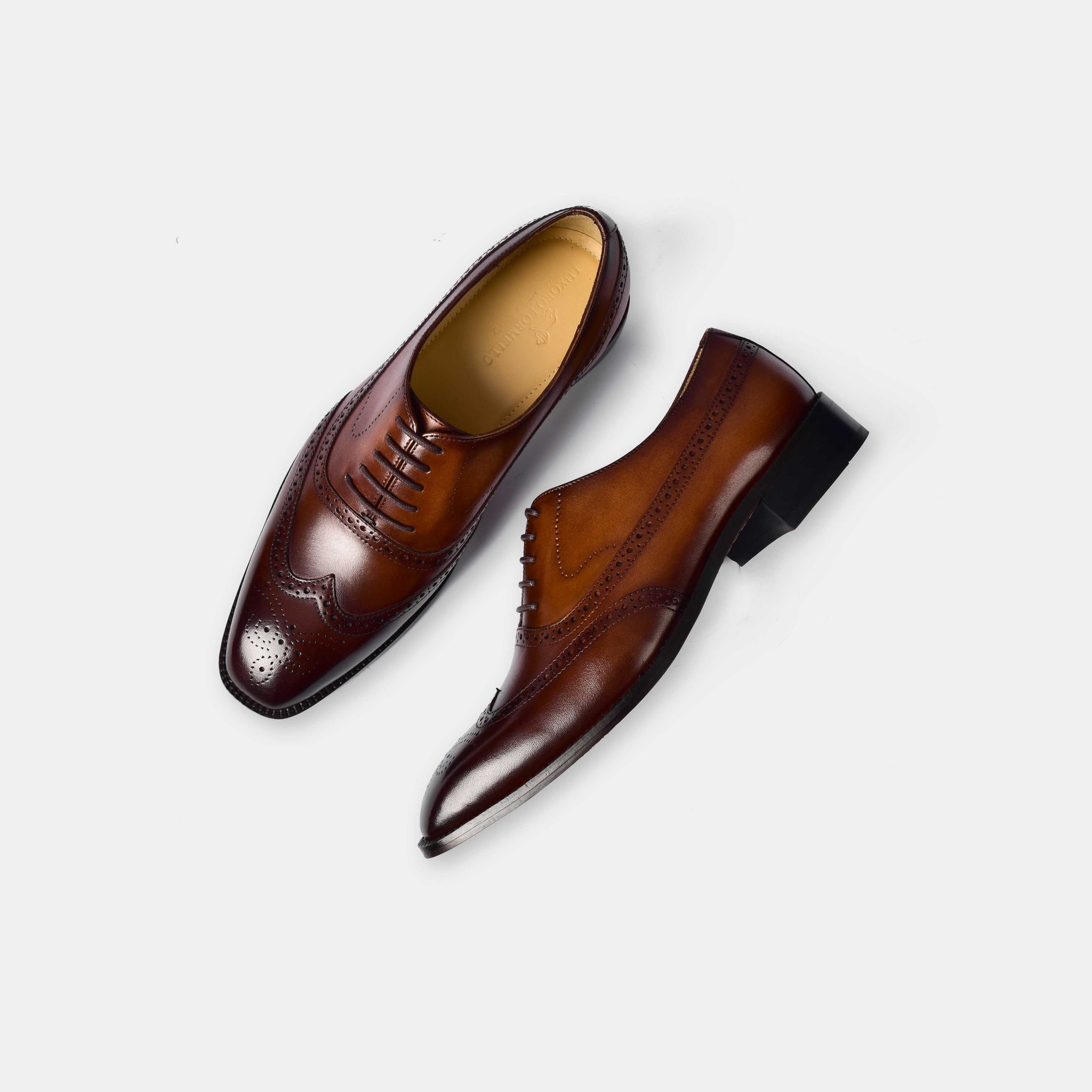 A pair of Melvin Litt Leather Laceups in brown leather, showcasing the classic brogue detailing and sleek silhouette.