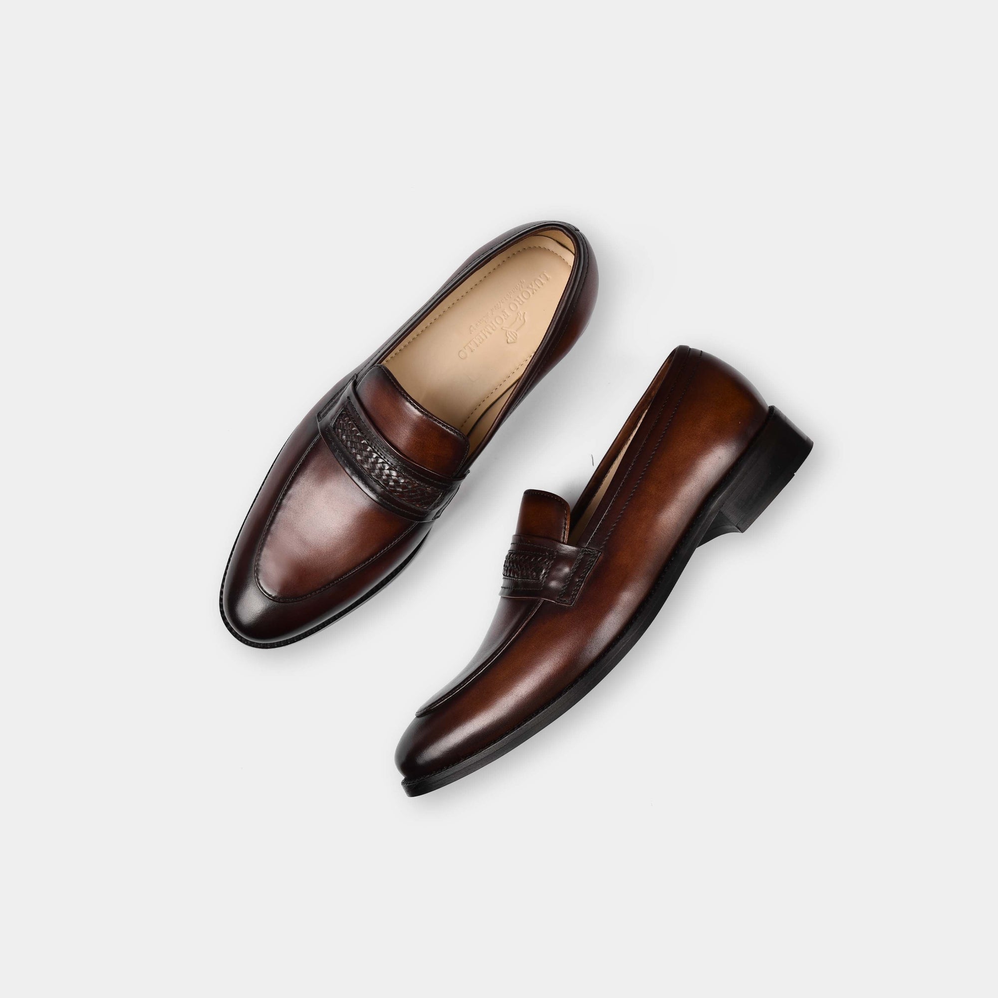 Pair of Tim Williams Leather Loafers in brown, showcasing the sleek design and leather saddle strap detail.