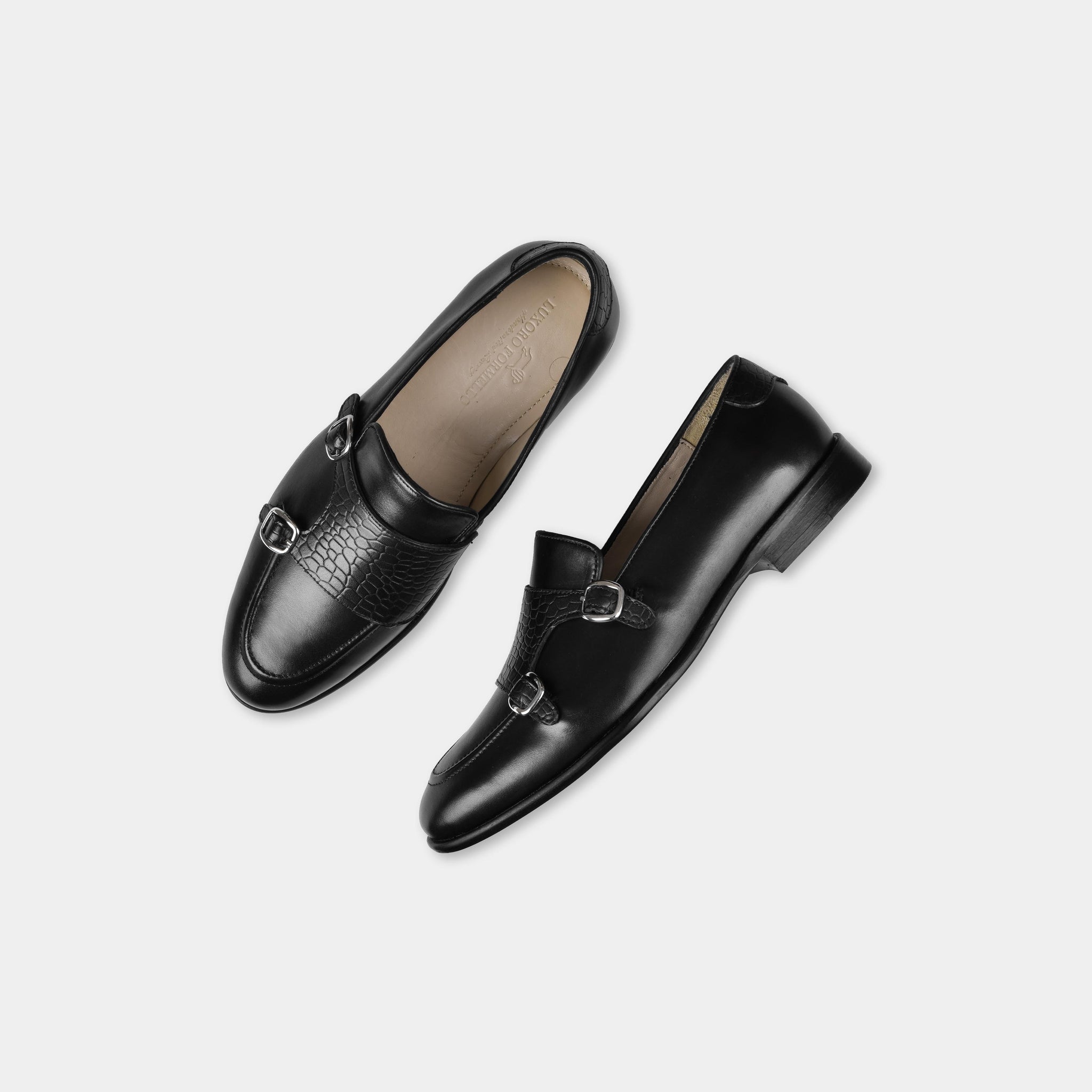 Pair of Armeo Black Leather Monk Straps shoes with double silver buckles and textured accent, top view.