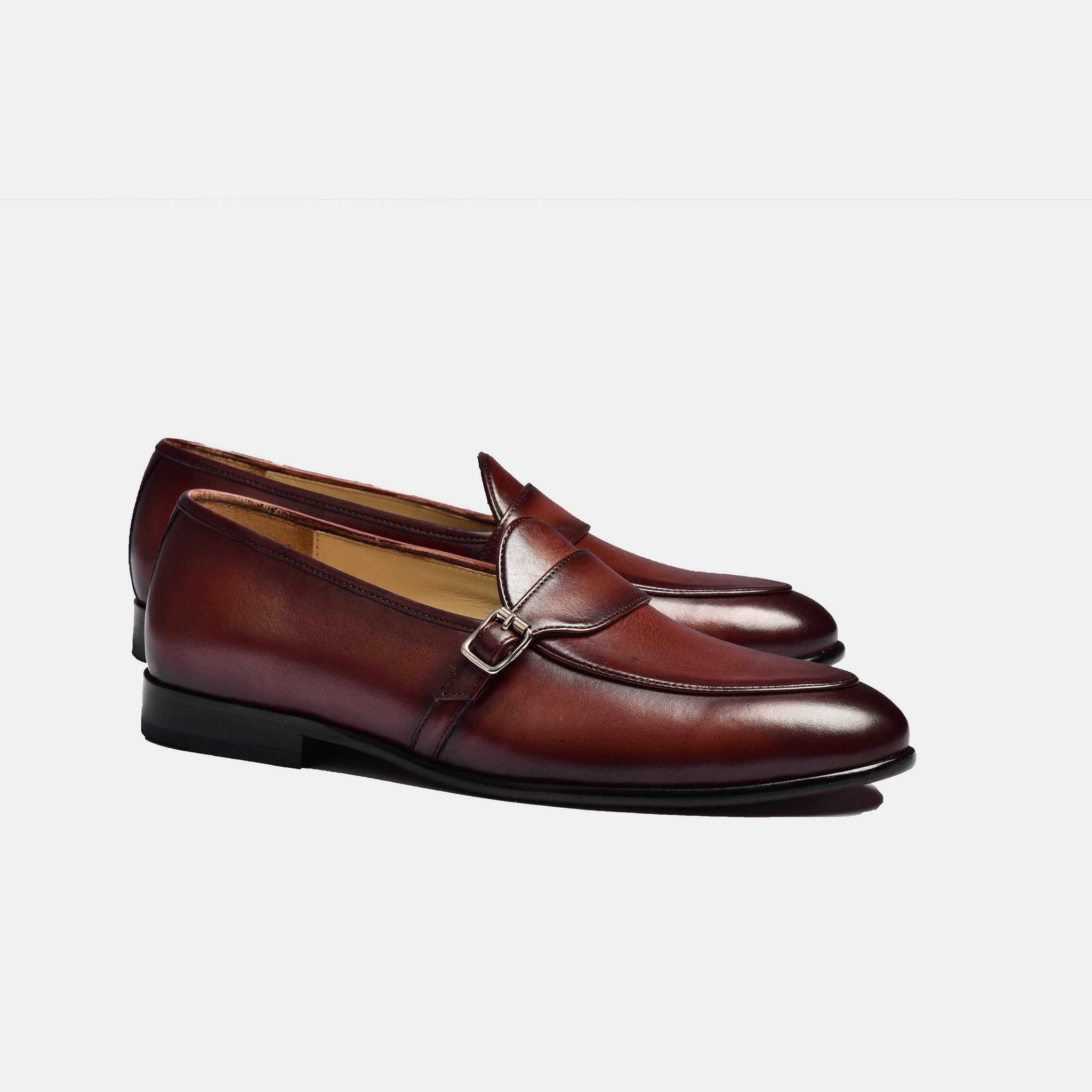 Pair of brown patina Arno Loafers with a single buckle strap across the front.