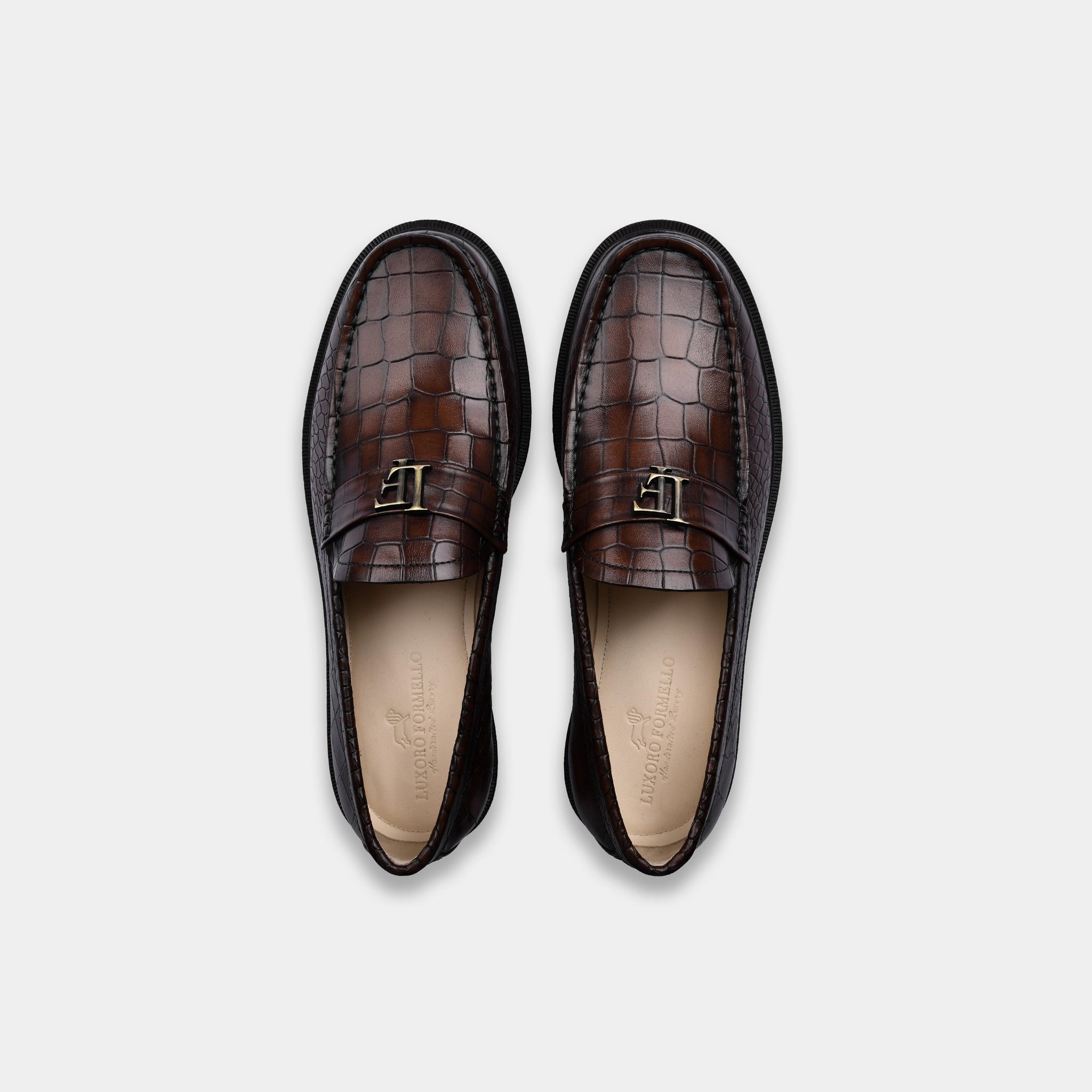 Pair of men's brown crocodile textured leather loafers, showcasing the slip-on design and hand-stitched details.