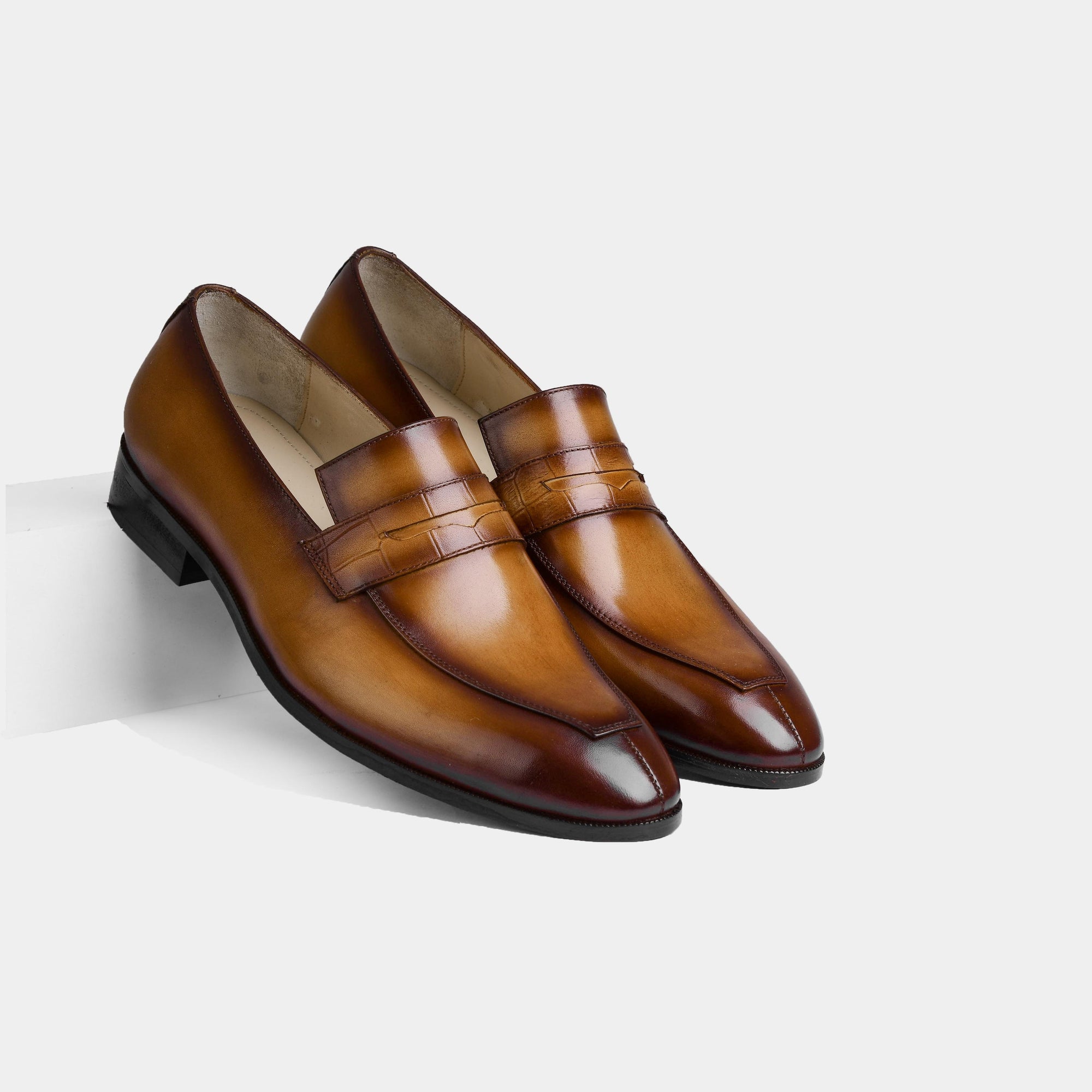 A pair of Lucero Walnut Leather Loafers with a burnished finish, showcasing their premium leather construction and timeless penny loafer design.