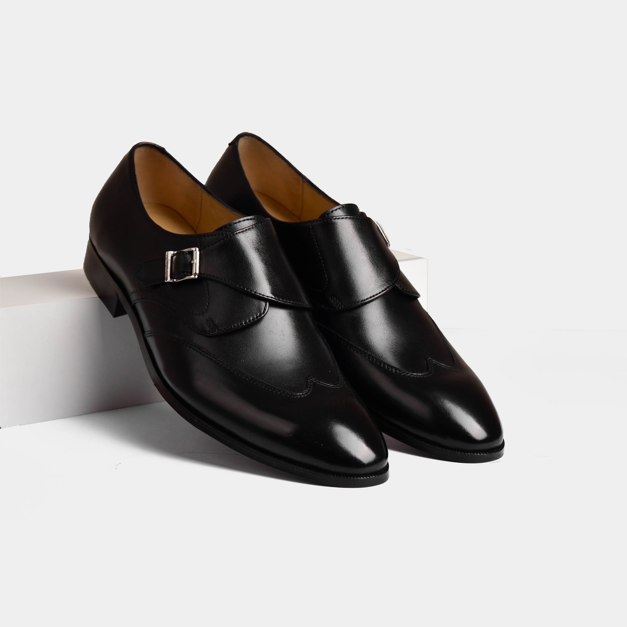 Pair of Garrett Black Leather Monk Straps with silver buckles on a white background.