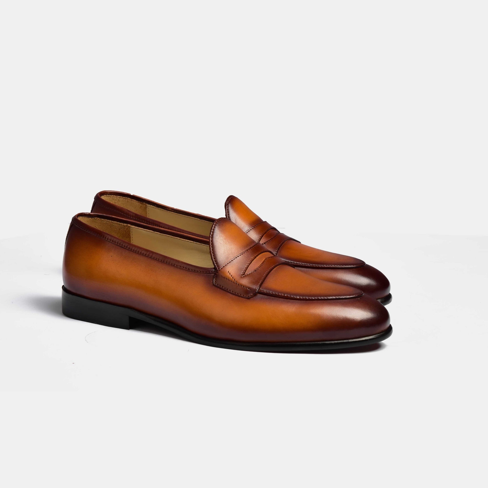 Pair of men's tan handpainted Arno loafers with a classic penny loafer design.