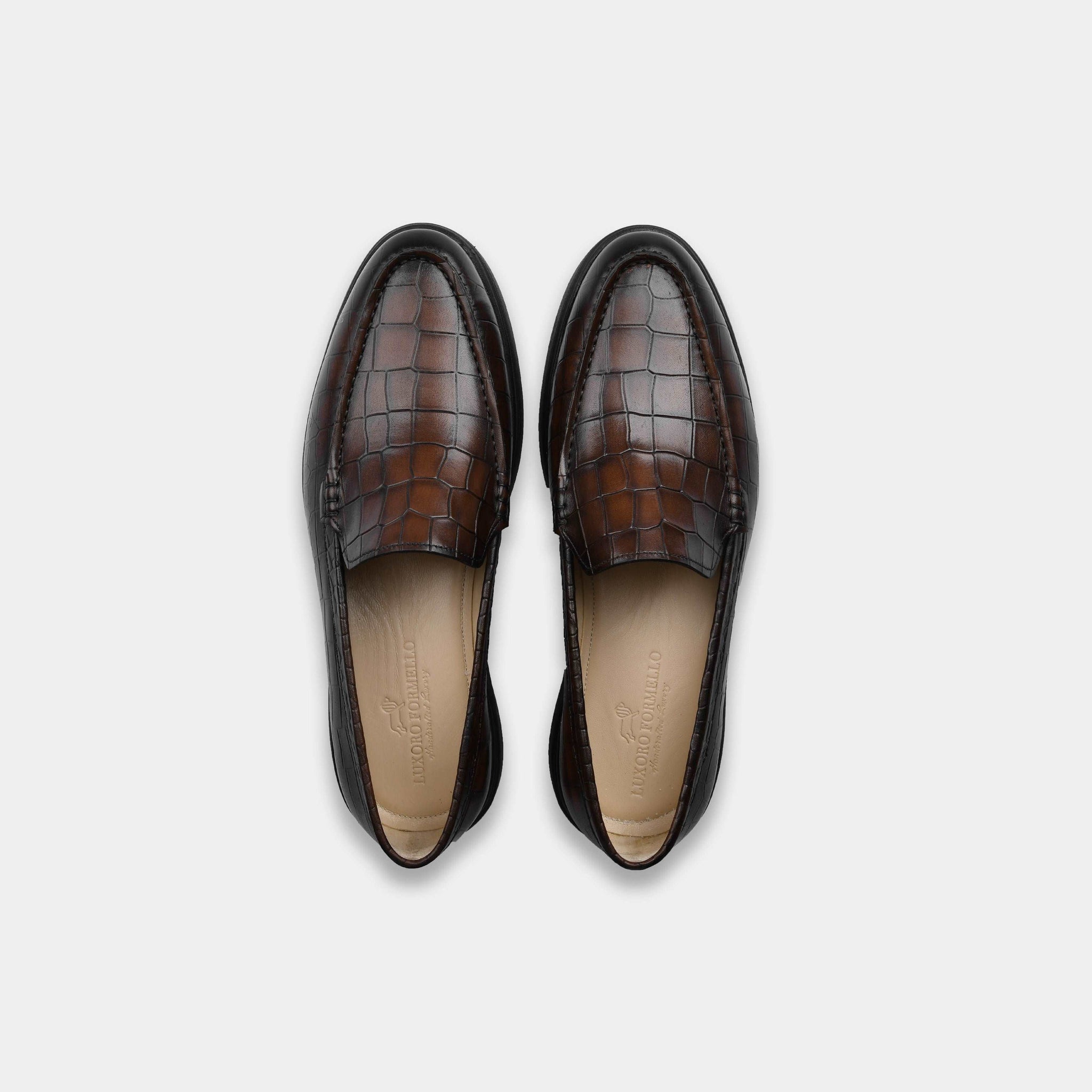 Pair of brown croc-embossed leather slip-on shoes for men, shown from above.