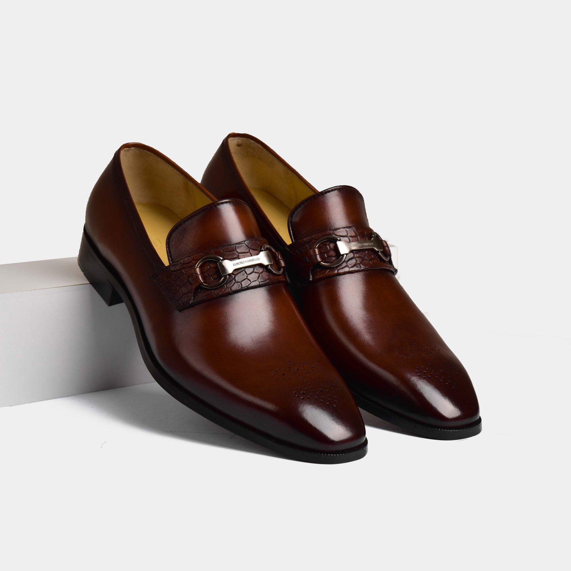 A pair of Diaz Choc Loafers, crafted from polished brown leather, featuring a stylish crocodile-embossed strap with a metal buckle accent.