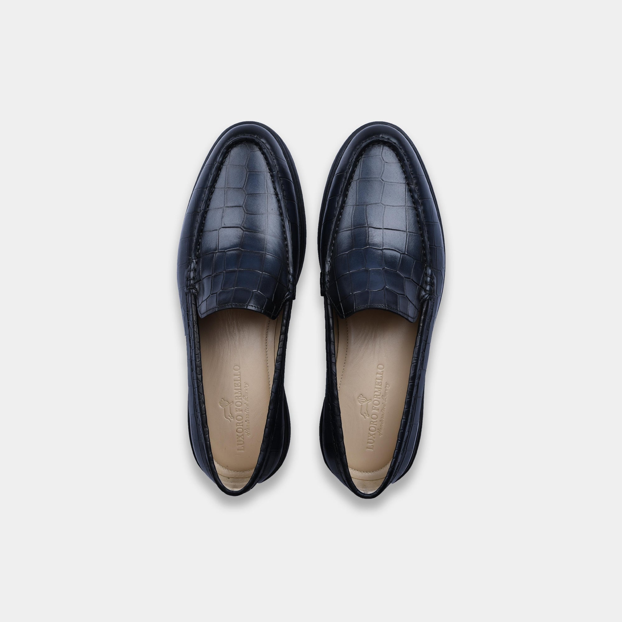 Pair of blue croc leather slip-on shoes, showcasing the upper and insole with the brand name visible.