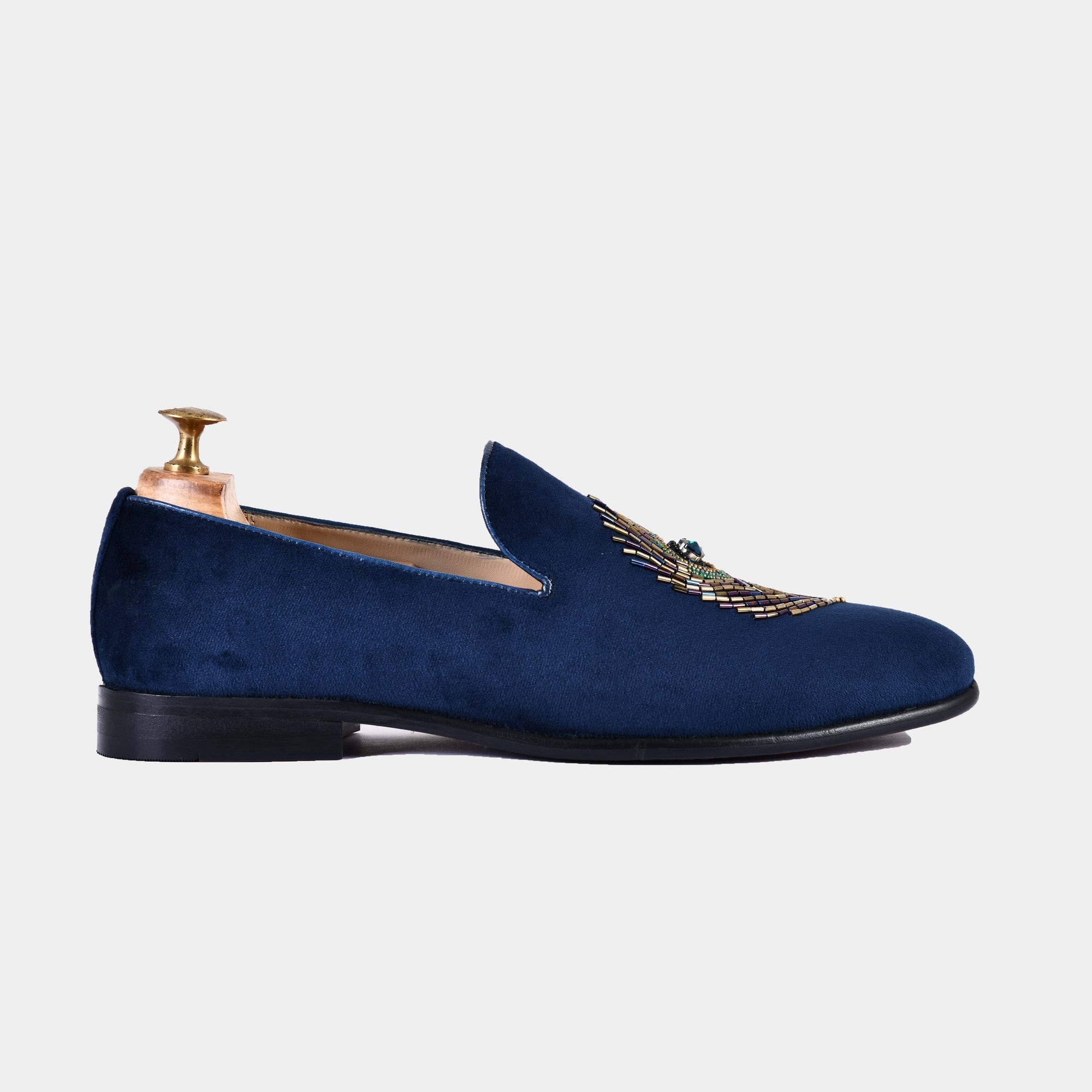 Side view of navy blue Artemio slip-on shoe with intricate beading detail on the vamp.