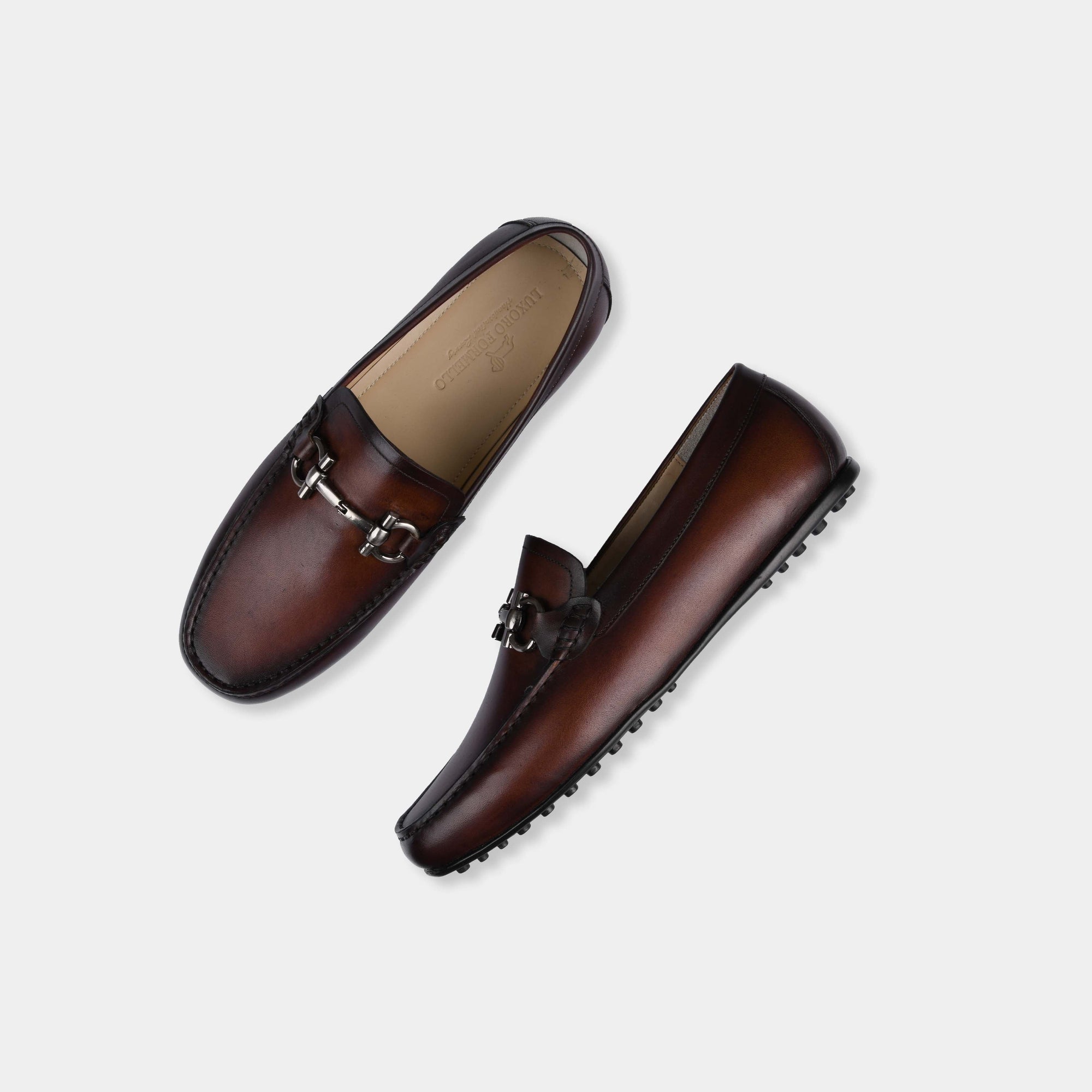 A pair of Helio Brown Leather Driving Loafers with a metal bit detail, showcasing their stylish design.