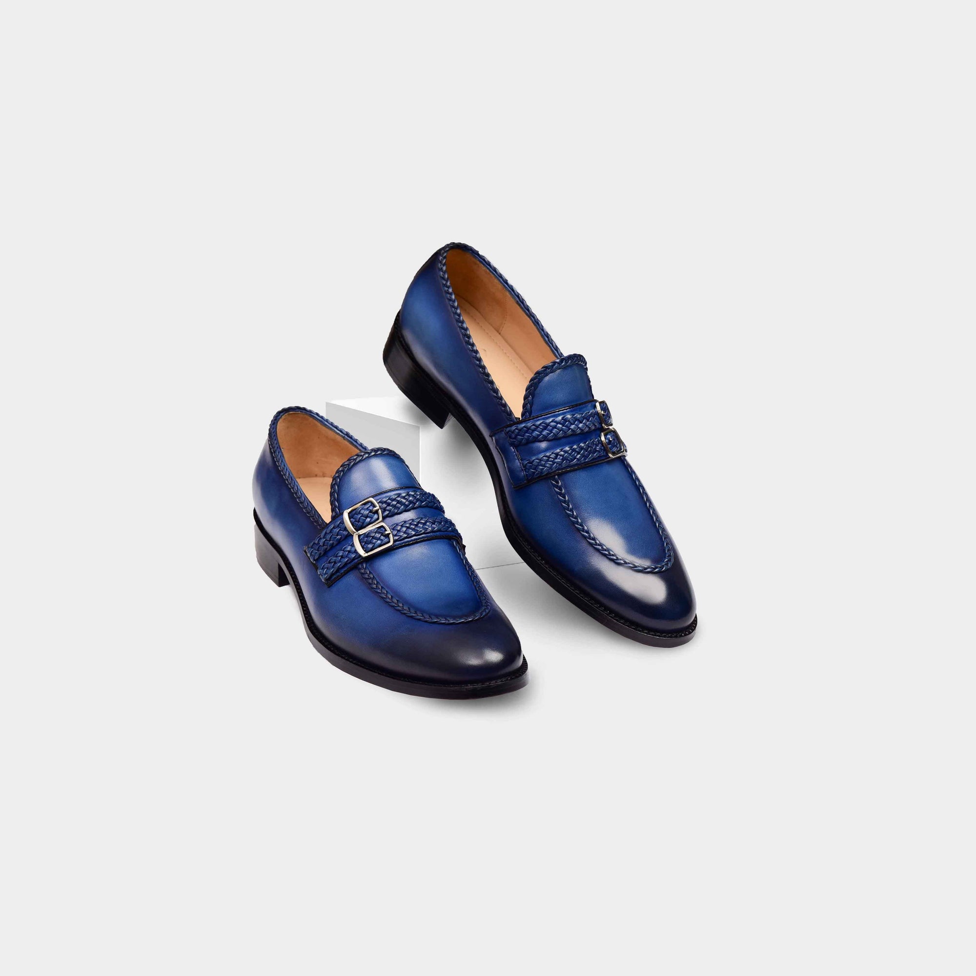 A pair of Jade Blue Double Monks Leather Loafers with a braided strap and buckle closure.