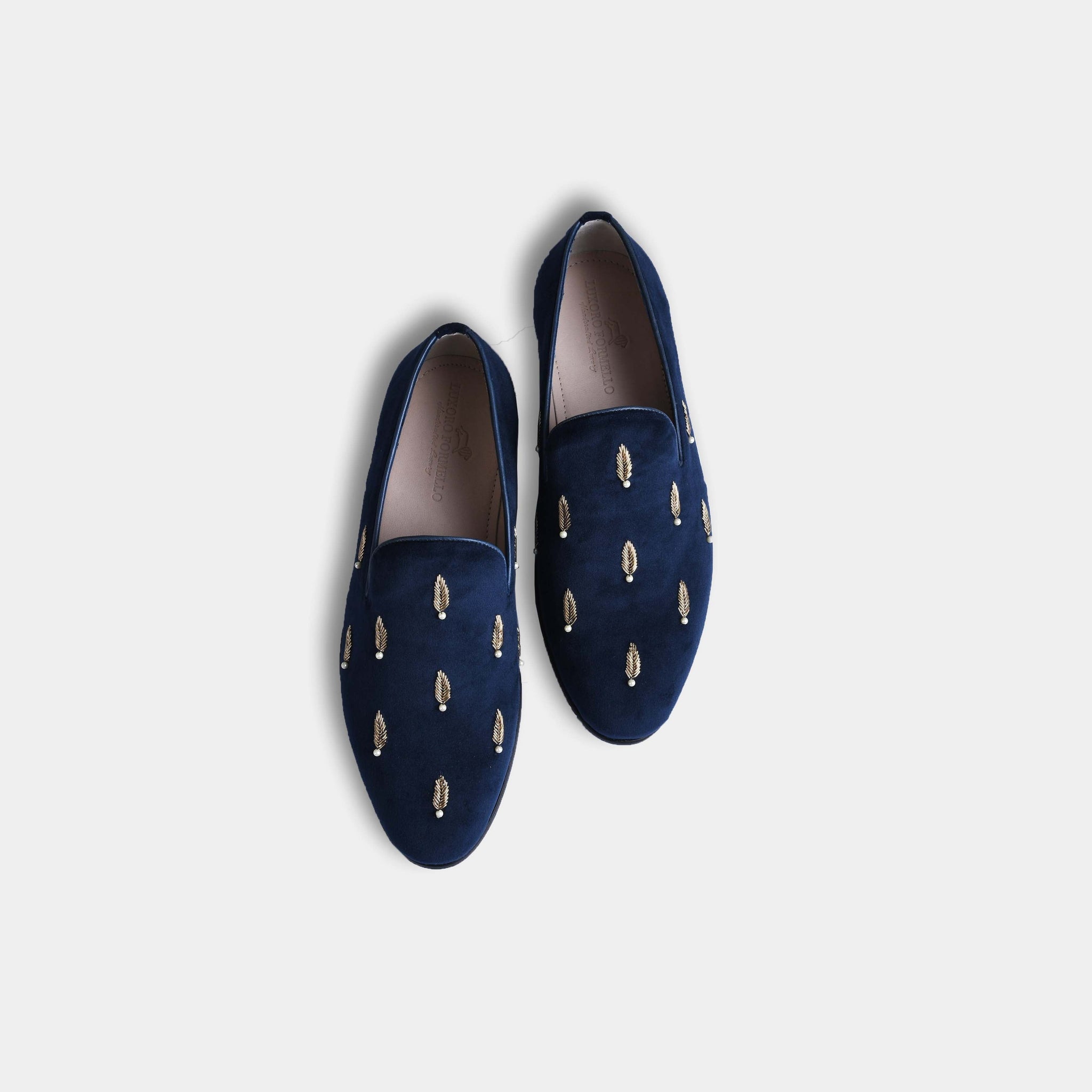 Pair of Carlos Blue Embroidered Leather Slip-Ons in navy blue velvet with gold embroidered leaves, shown from above on a white background.