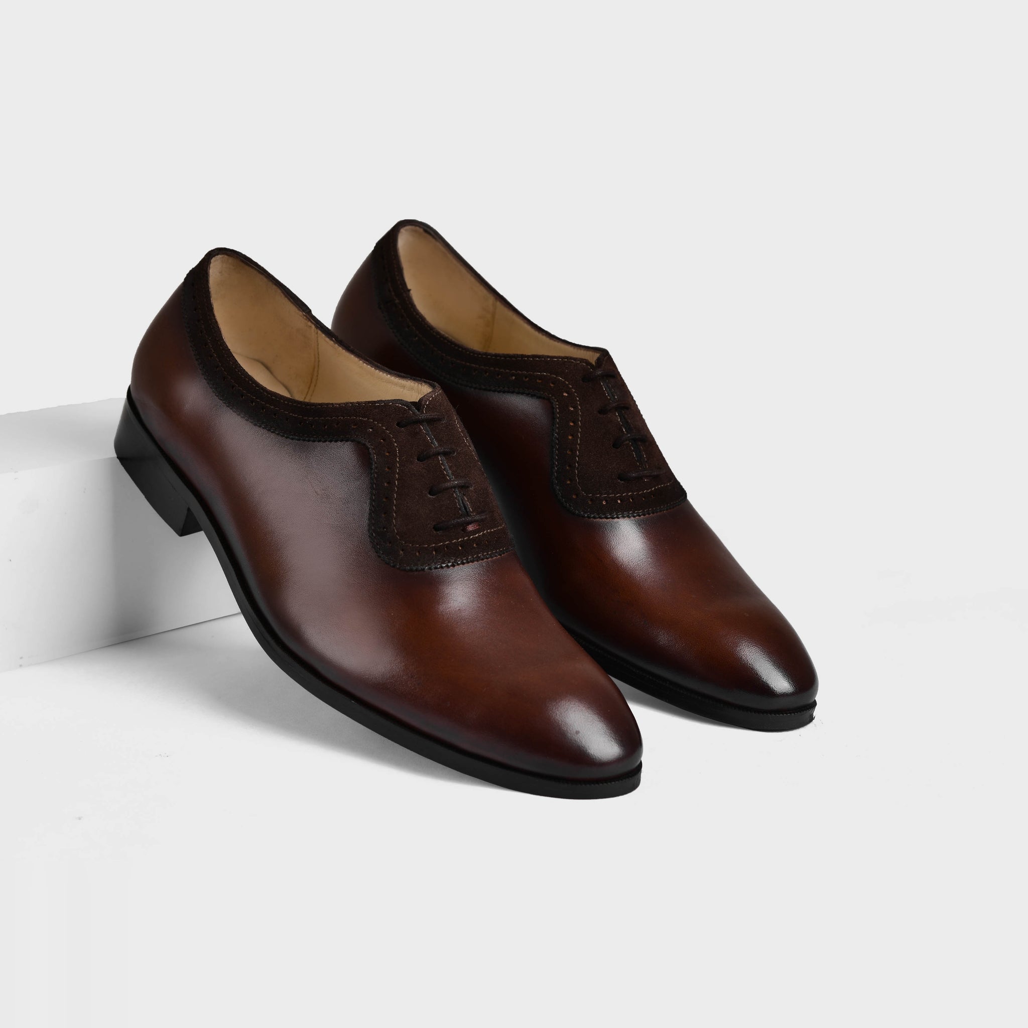 A pair of Orlan Brown Leather Laceups with decorative broguing and a sleek, polished finish.