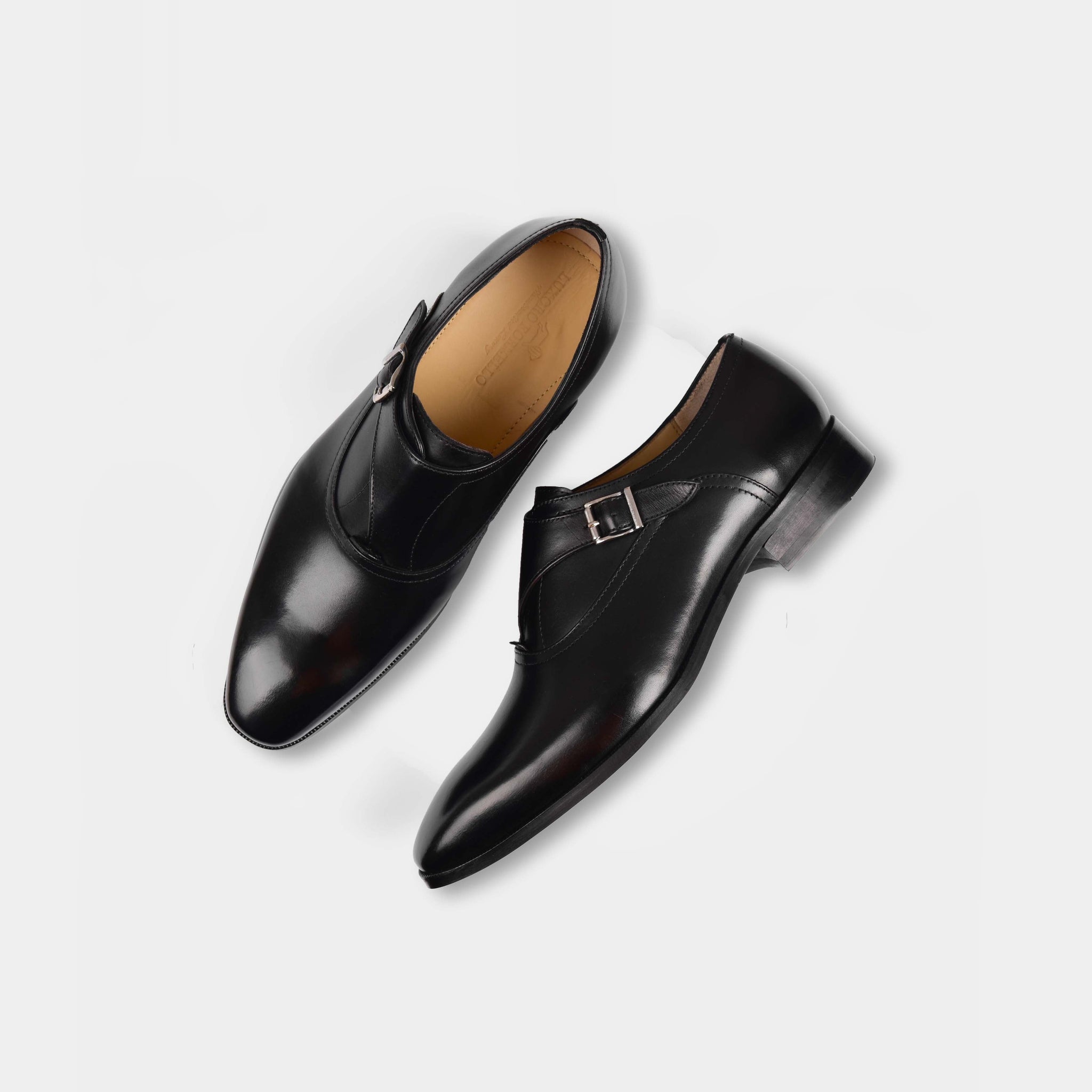 Pair of Reina Black Monk Strap shoes on a white background.